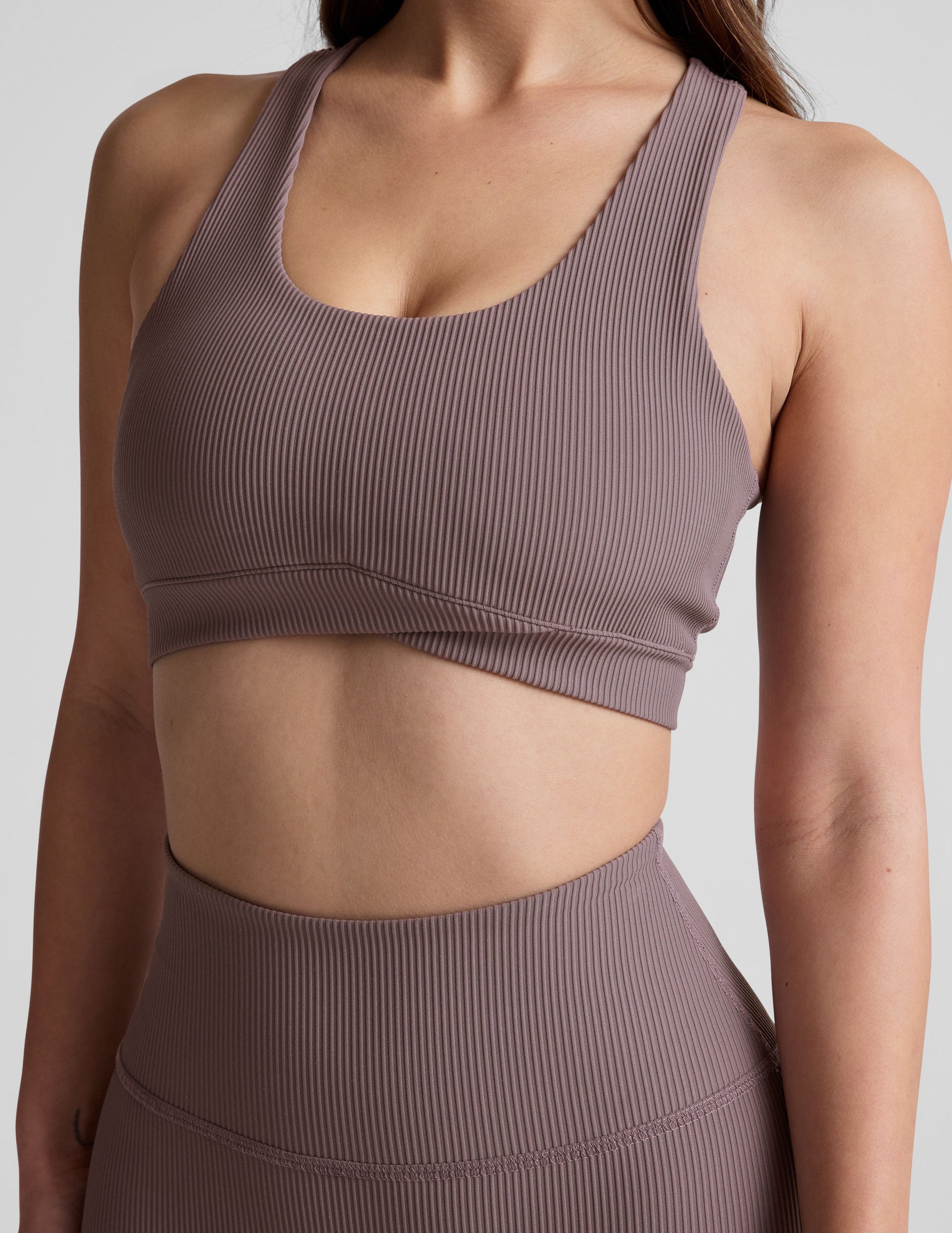 brown medium support racerback bra with a scoop neckline, overlapping hemband detail, is lined with performance lining and powermesh in between, and has removable bra pads.