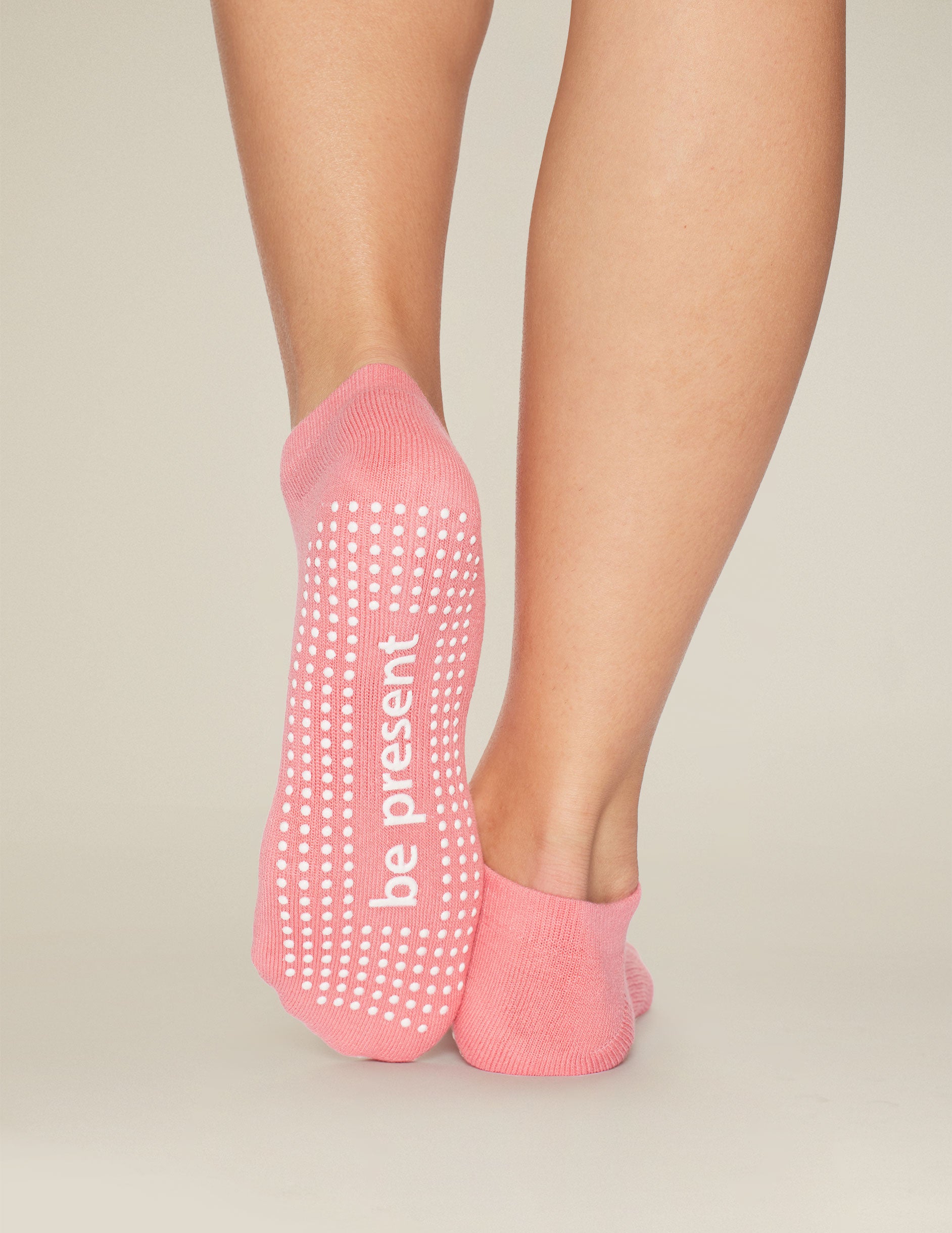 pink ankle grip socks with the mantra "be present" printed. 