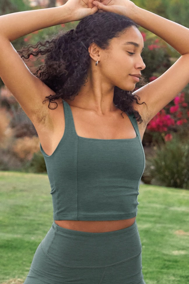 model is wearing a green square neck cropped tank top. 