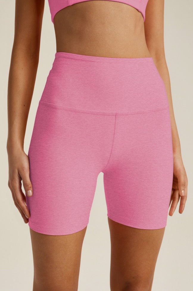 model is wearing pink high-waisted biker shorts. 