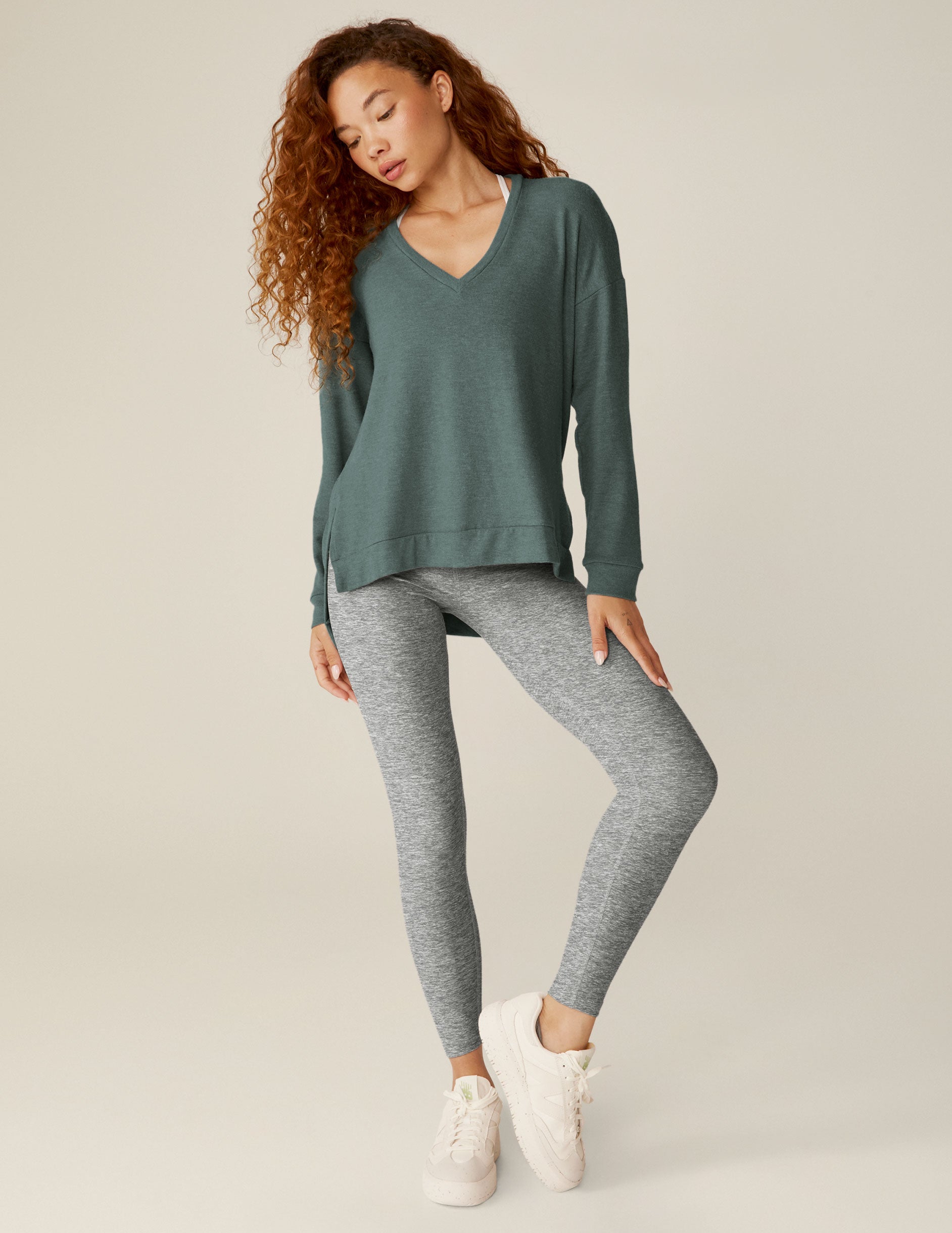 blue v-neck pullover sweater with a high-low detail at waistband and side slits. 