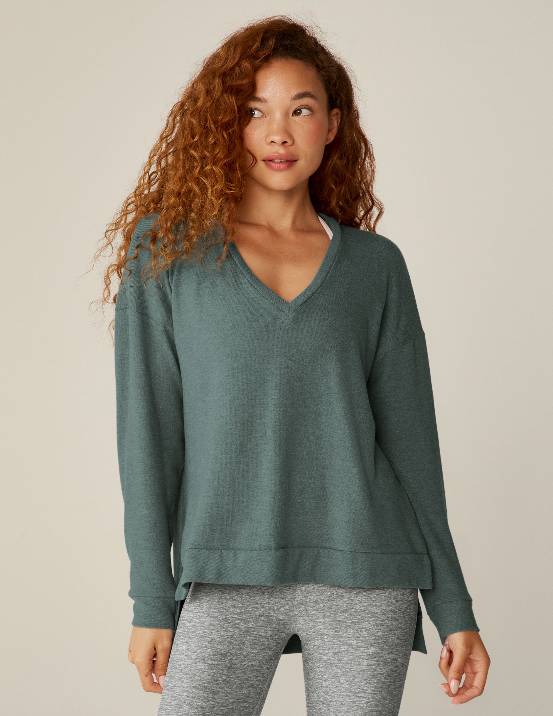 blue v-neck pullover sweater with a high-low detail at waistband and side slits. 