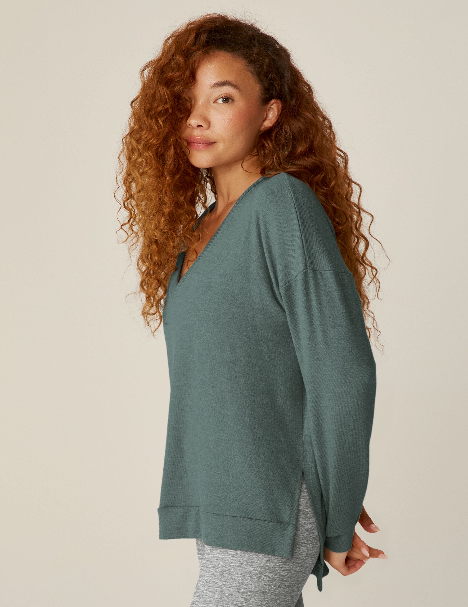 blue v-neck pullover sweater with a high-low detail at waistband and side slits. 