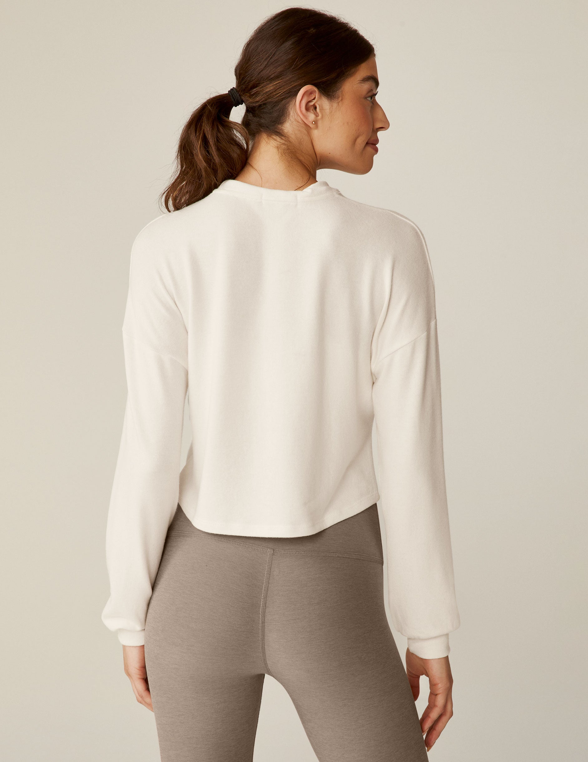 white crew neck relaxed fit cropped pullover with a detailing twist at front waist. 