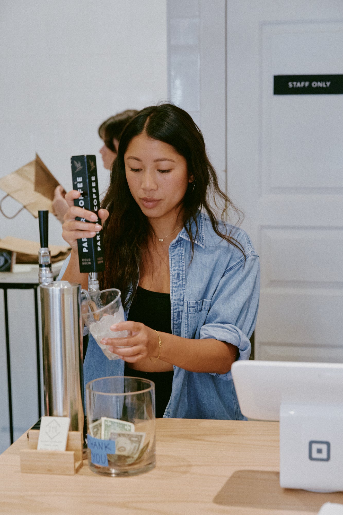 Claie pulling cold brew for customer