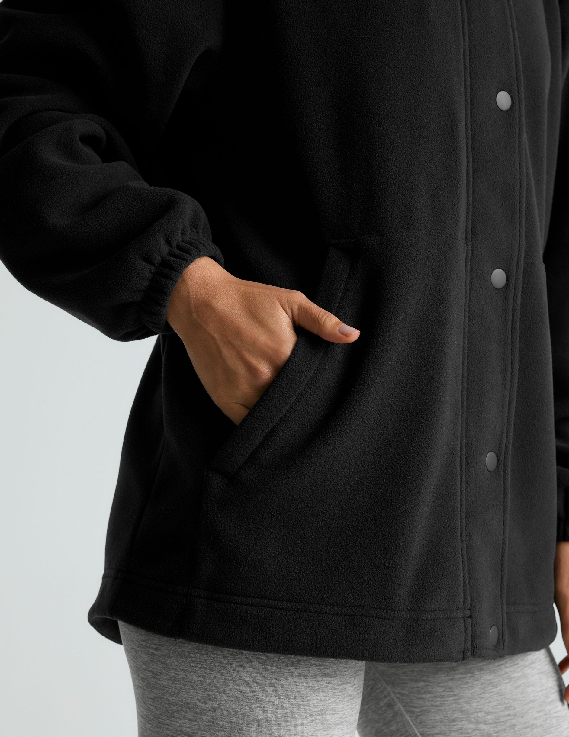black fleece button-up jacket with side pockets.