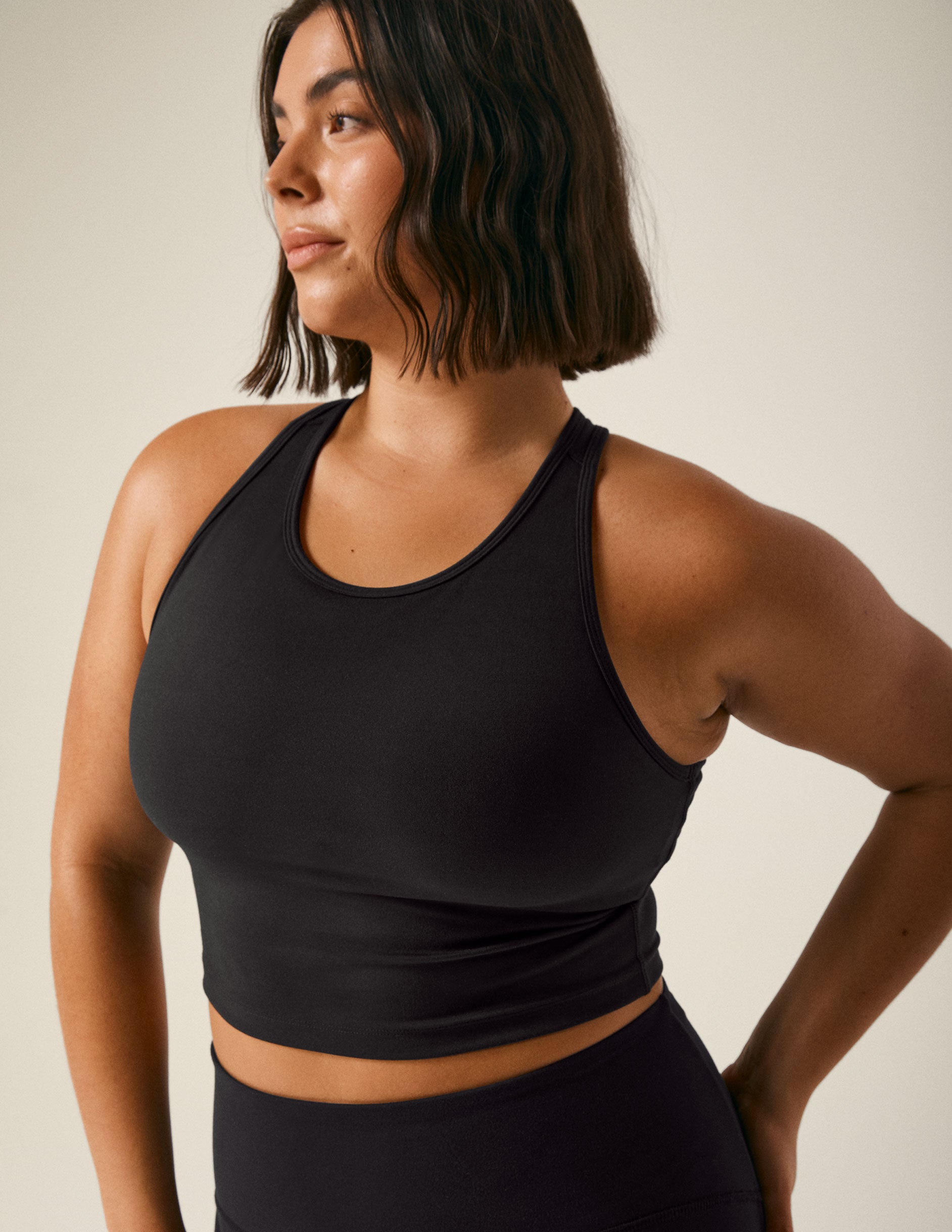 black scoop neck cropped tank with an open back detail held with bartacks.