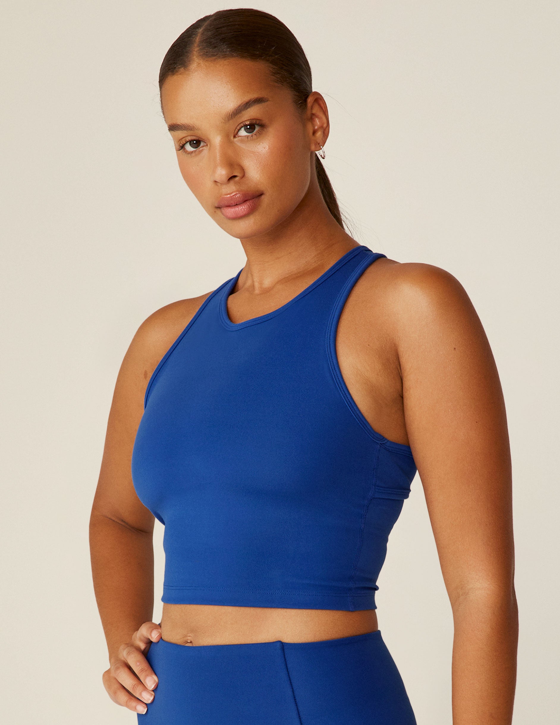 blue scoop neck racerback cropped tank with an open back detail held with bartacks.