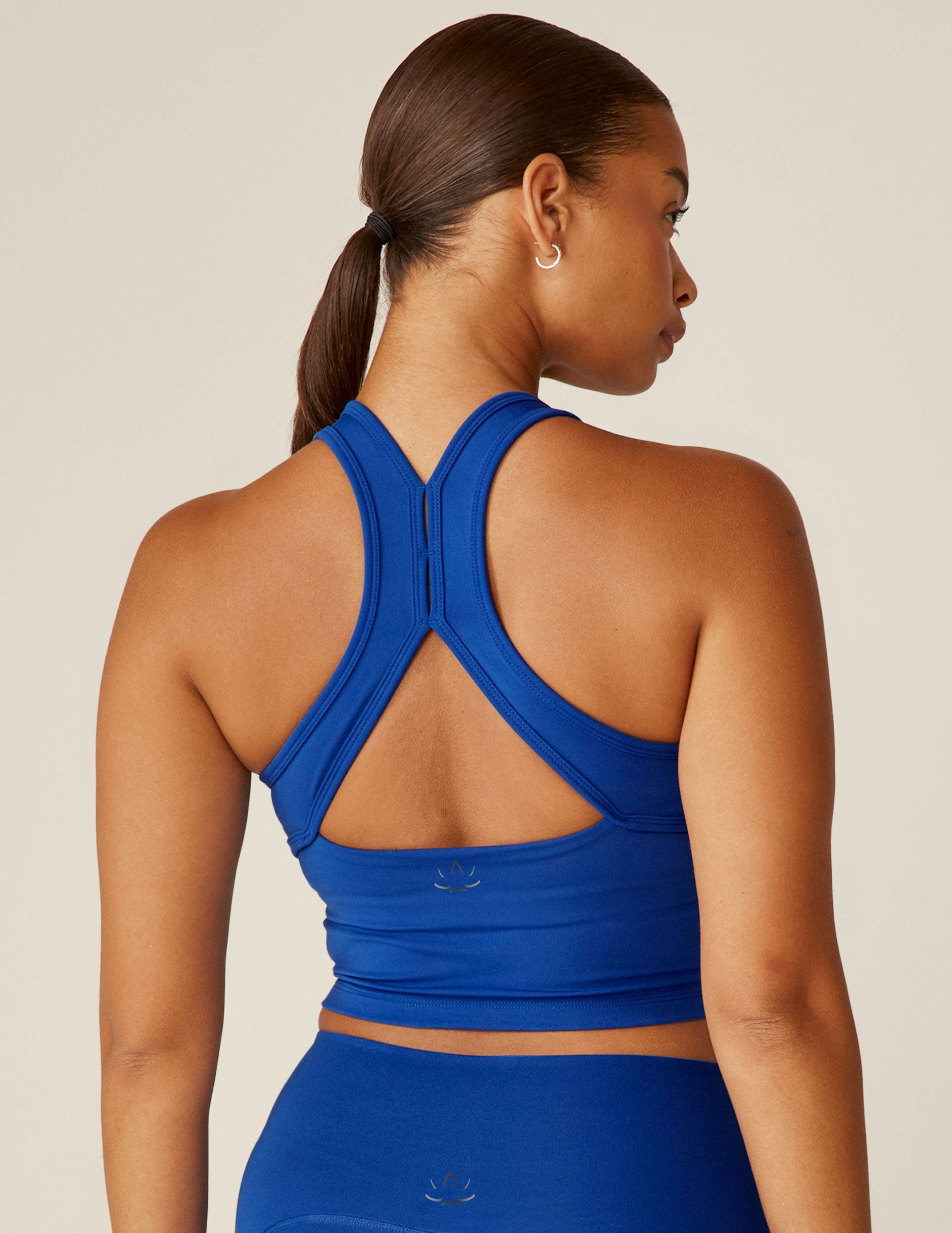 blue scoop neck racerback cropped tank with an open back detail held with bartacks.