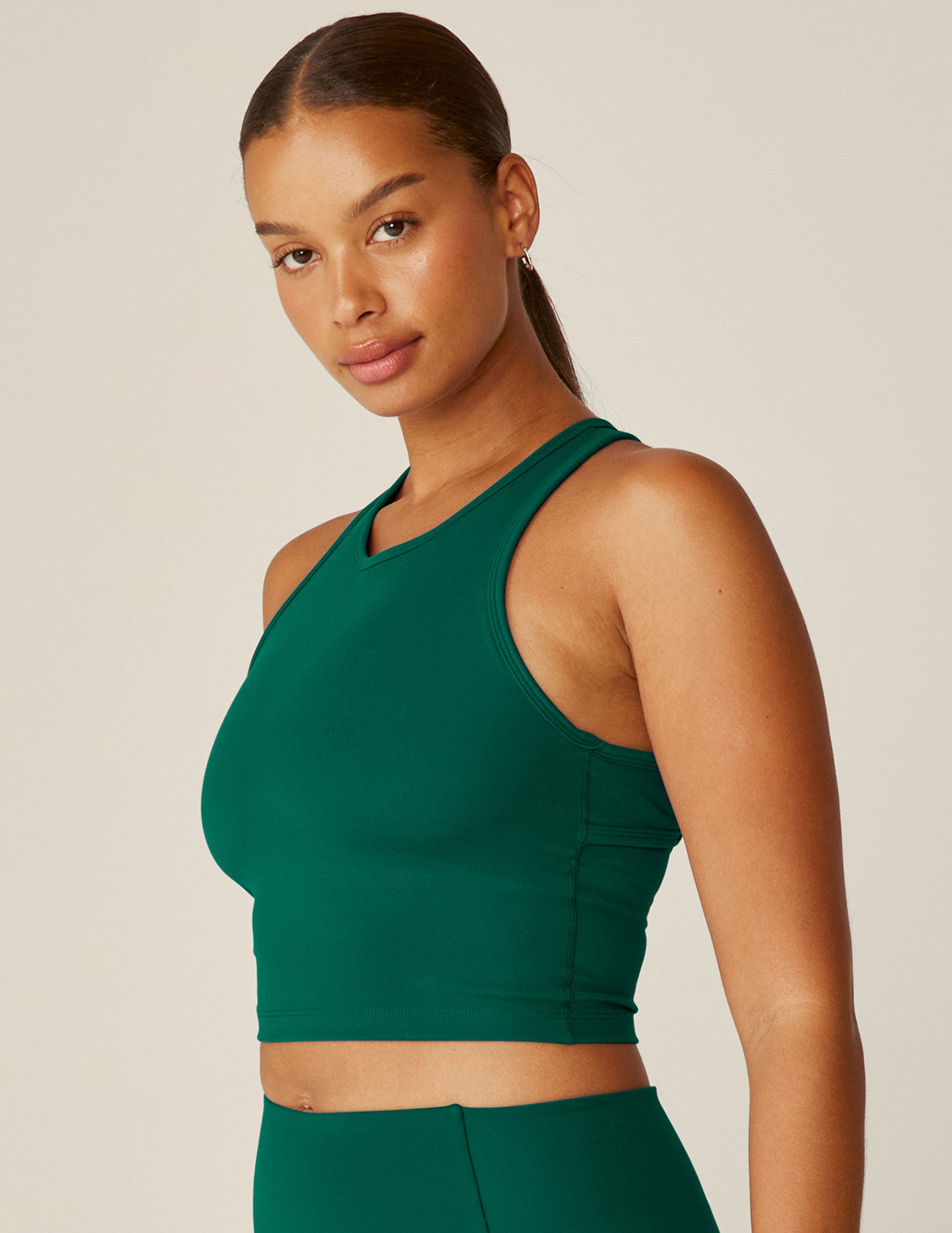 green scoop neck racerback cropped tank with an open back detail held with bartacks.