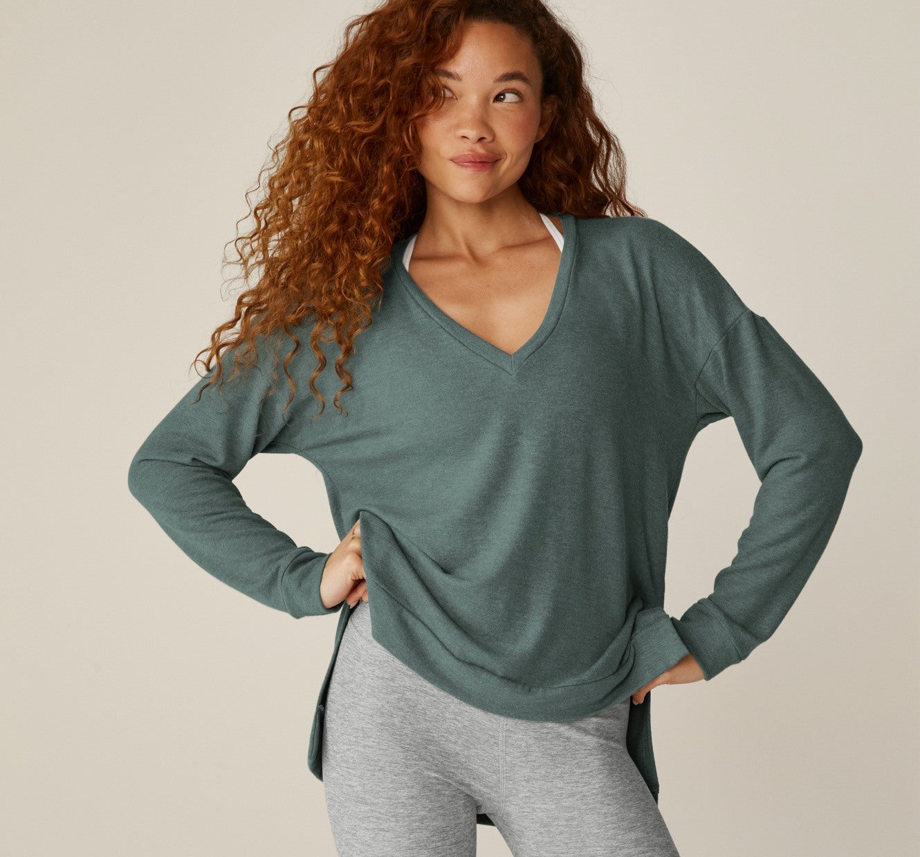 model is wearing a green v-neck sweater. 