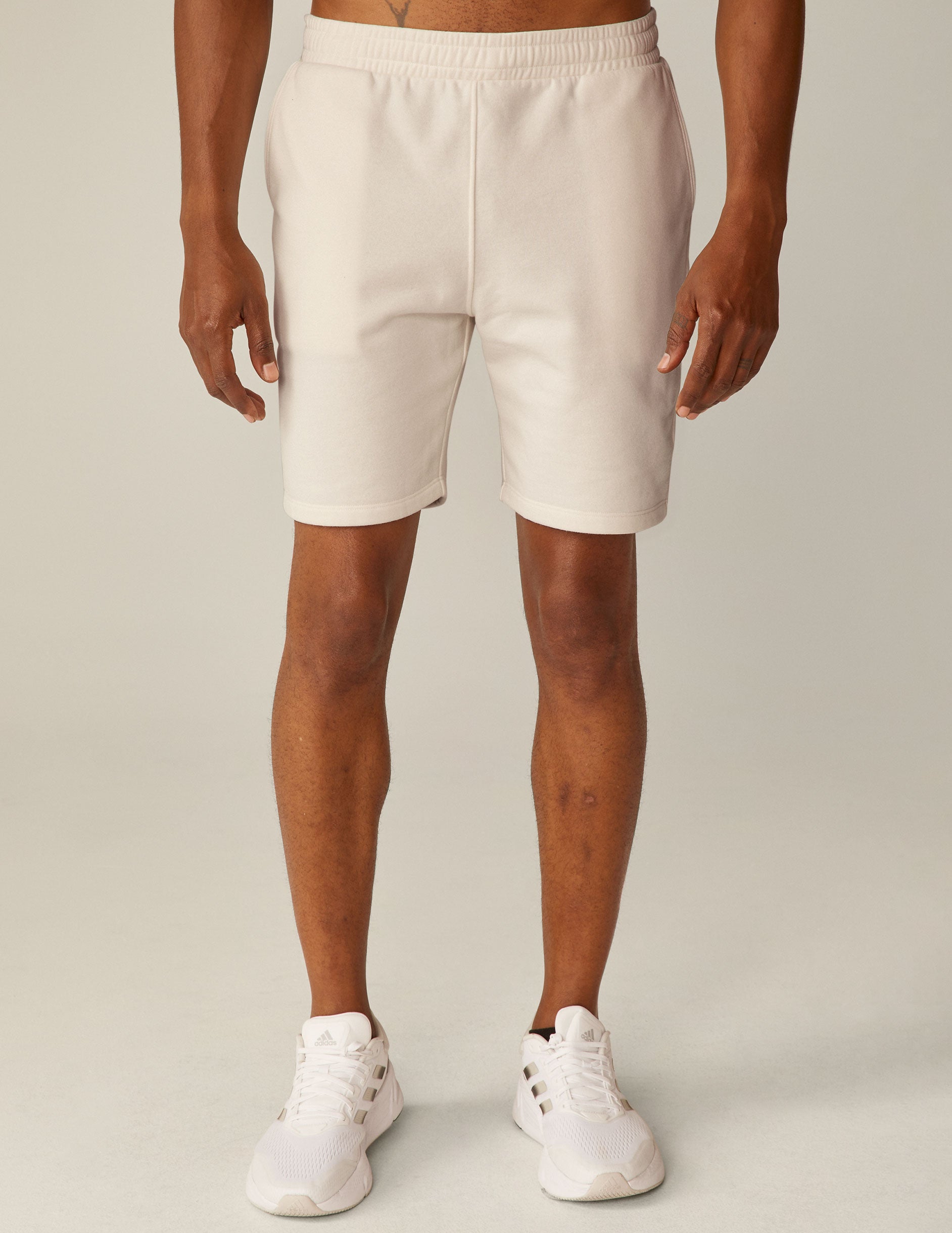 model is wearing white men's sweatshorts with pockets. 