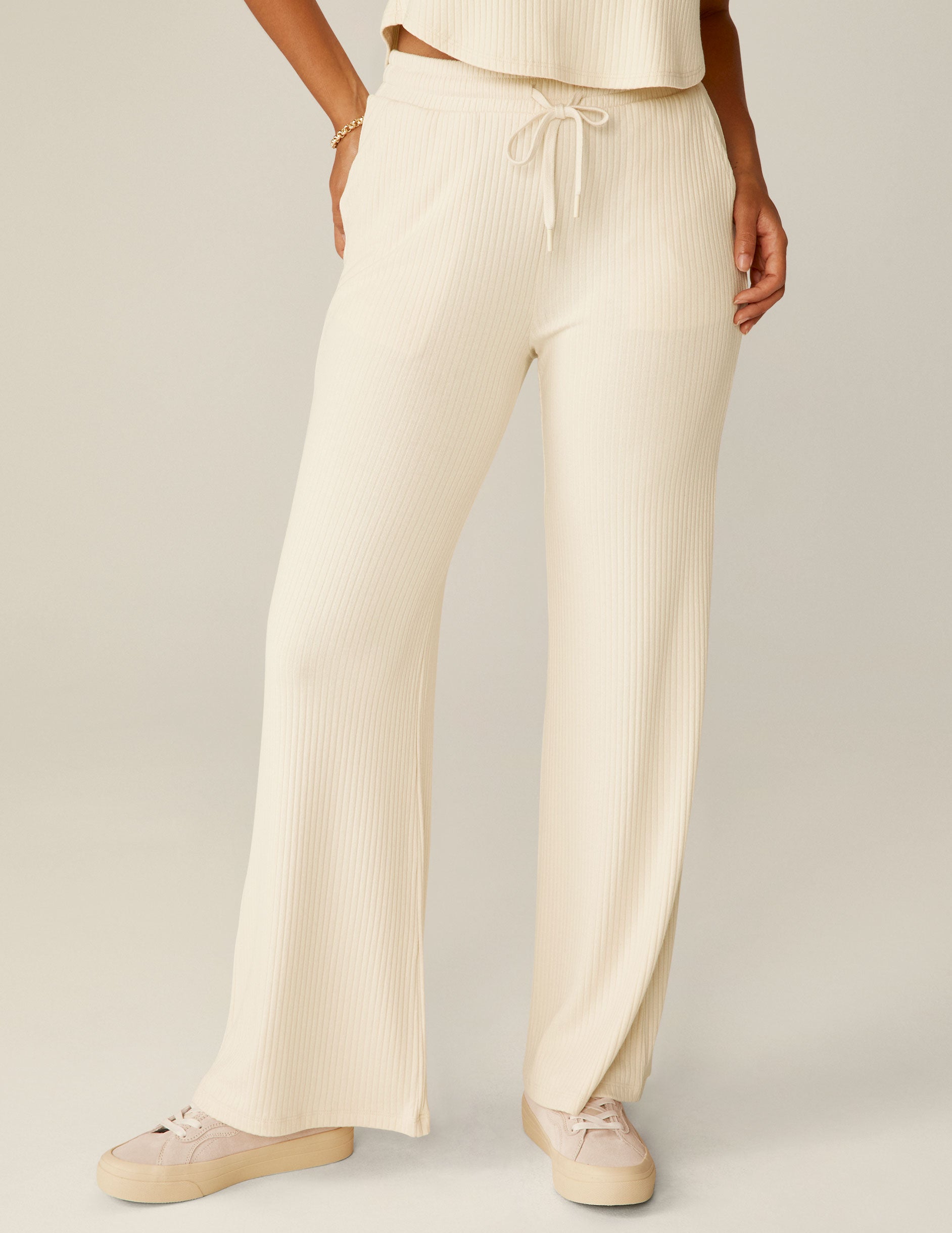 white high-rise ribbed wide leg pants with a drawstring at the waistband. 