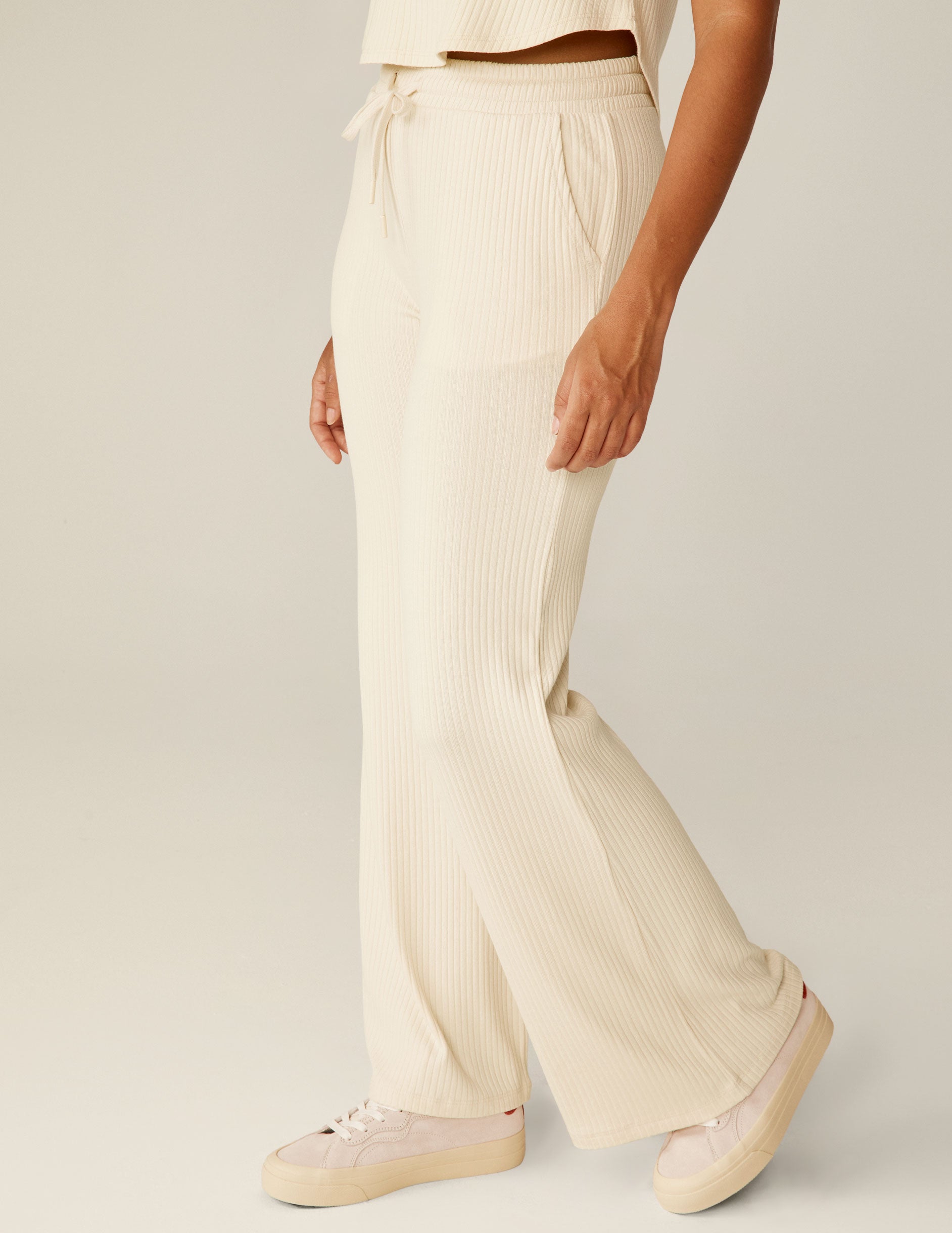 white high-rise ribbed wide leg pants with a drawstring at the waistband. 