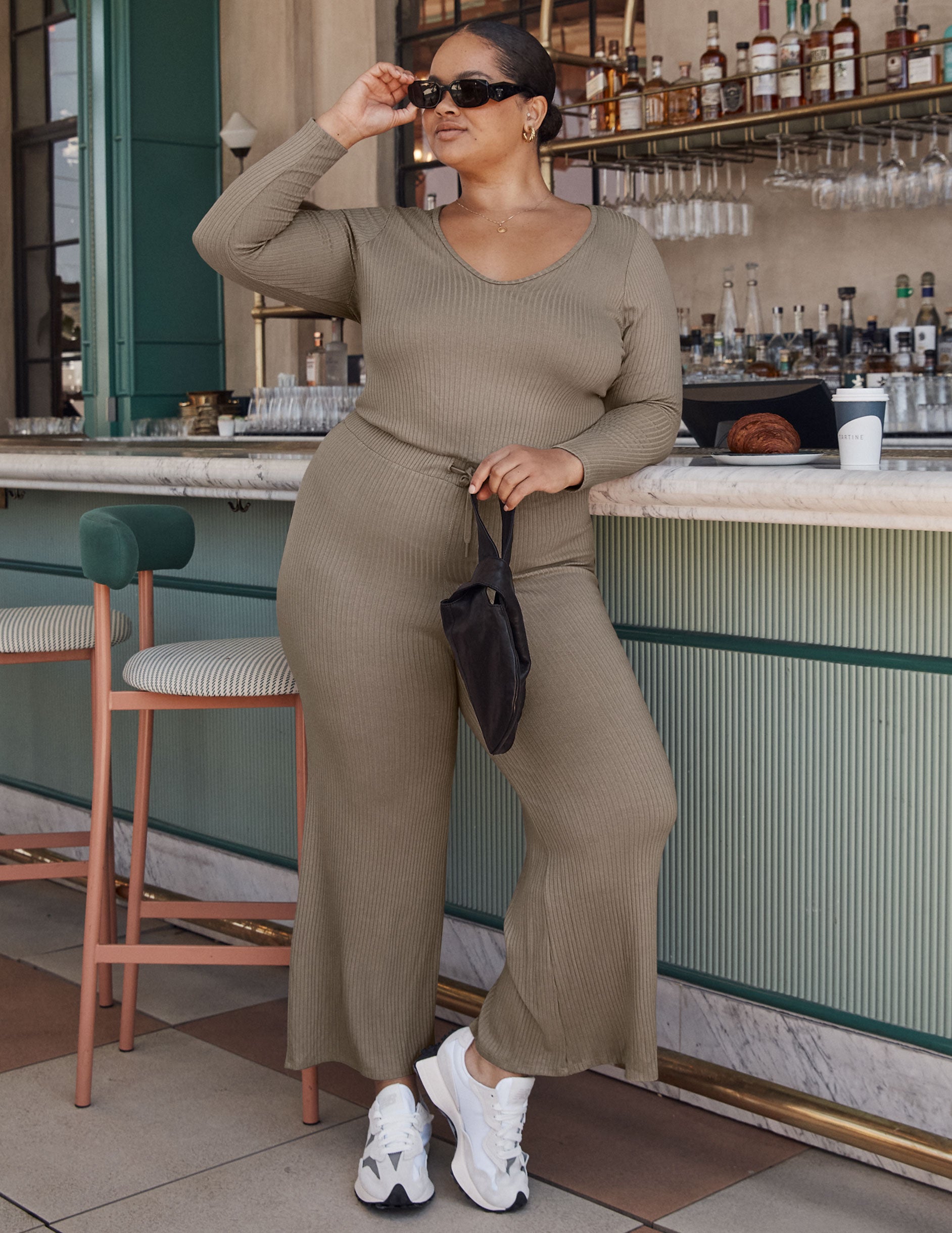 brown v-neck ribbed long sleeve jumpsuit with a drawstring at the waistband. 