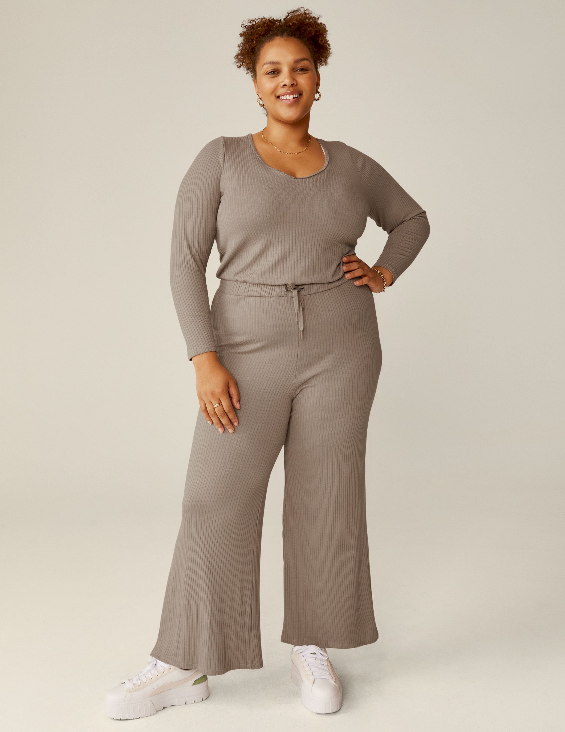 brown v-neck ribbed long sleeve jumpsuit with a drawstring at the waistband. 