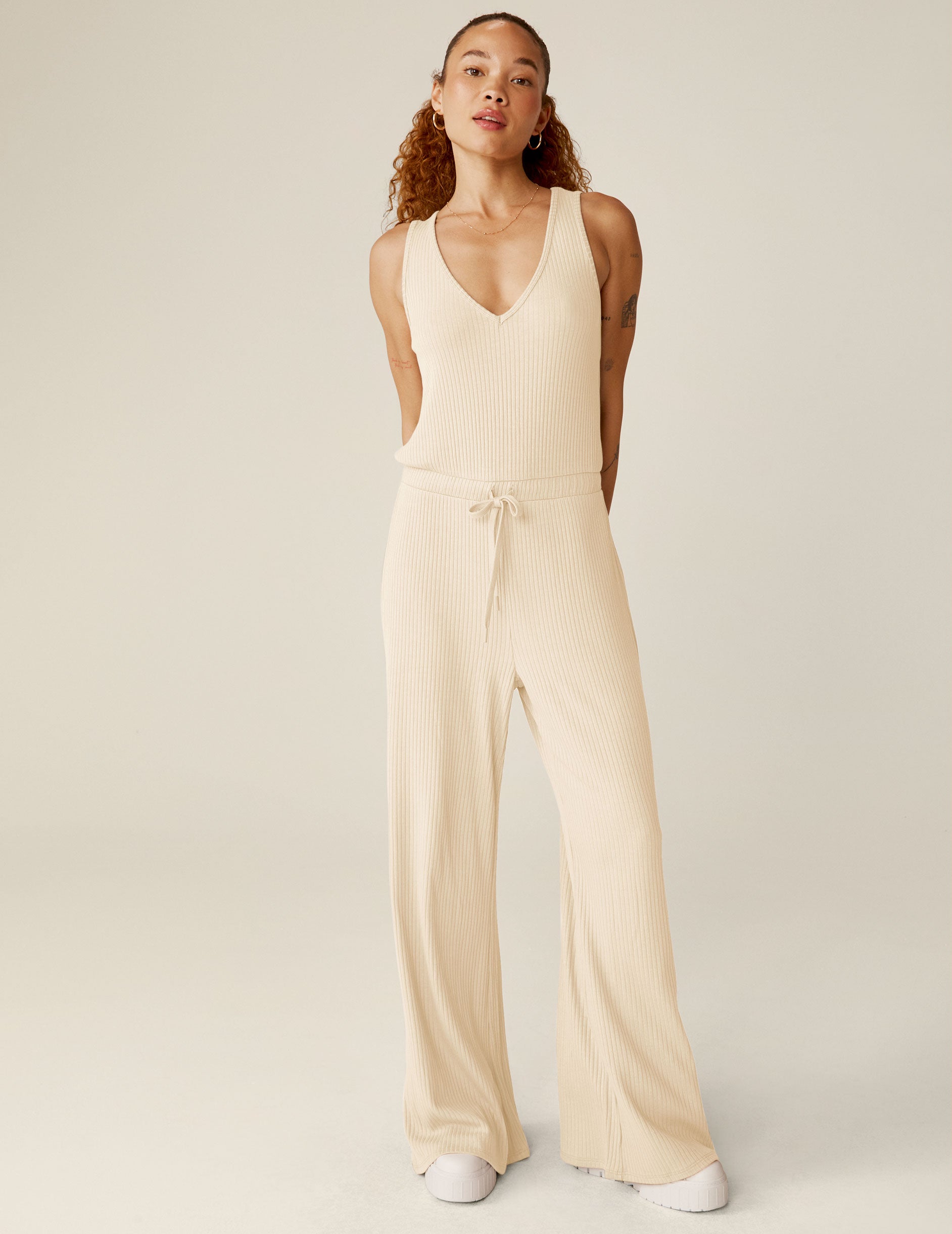 white v-neck ribbed jumpsuit with a drawstring at waistband. 