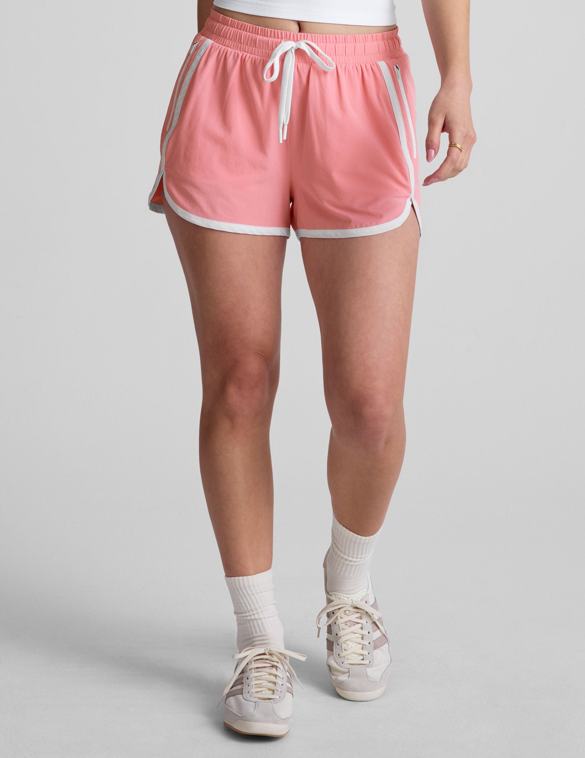 pink 2.5" inseam short with an encased elastic at waistband with drawcord, self binding at hem edges, side zipper pockets, and interior performance lining shorts.