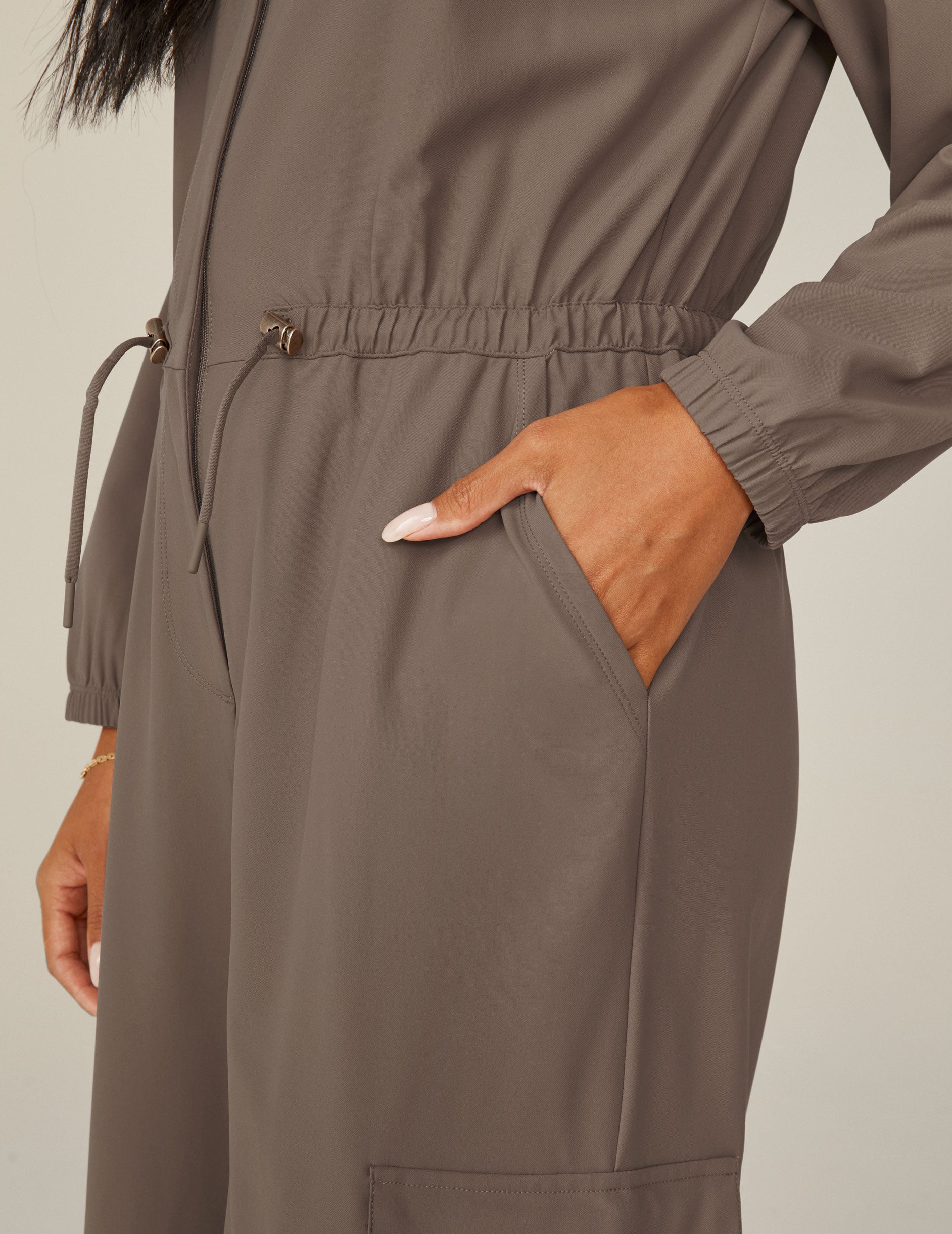 brown long sleeve cargo style jumpsuit with pockets. 