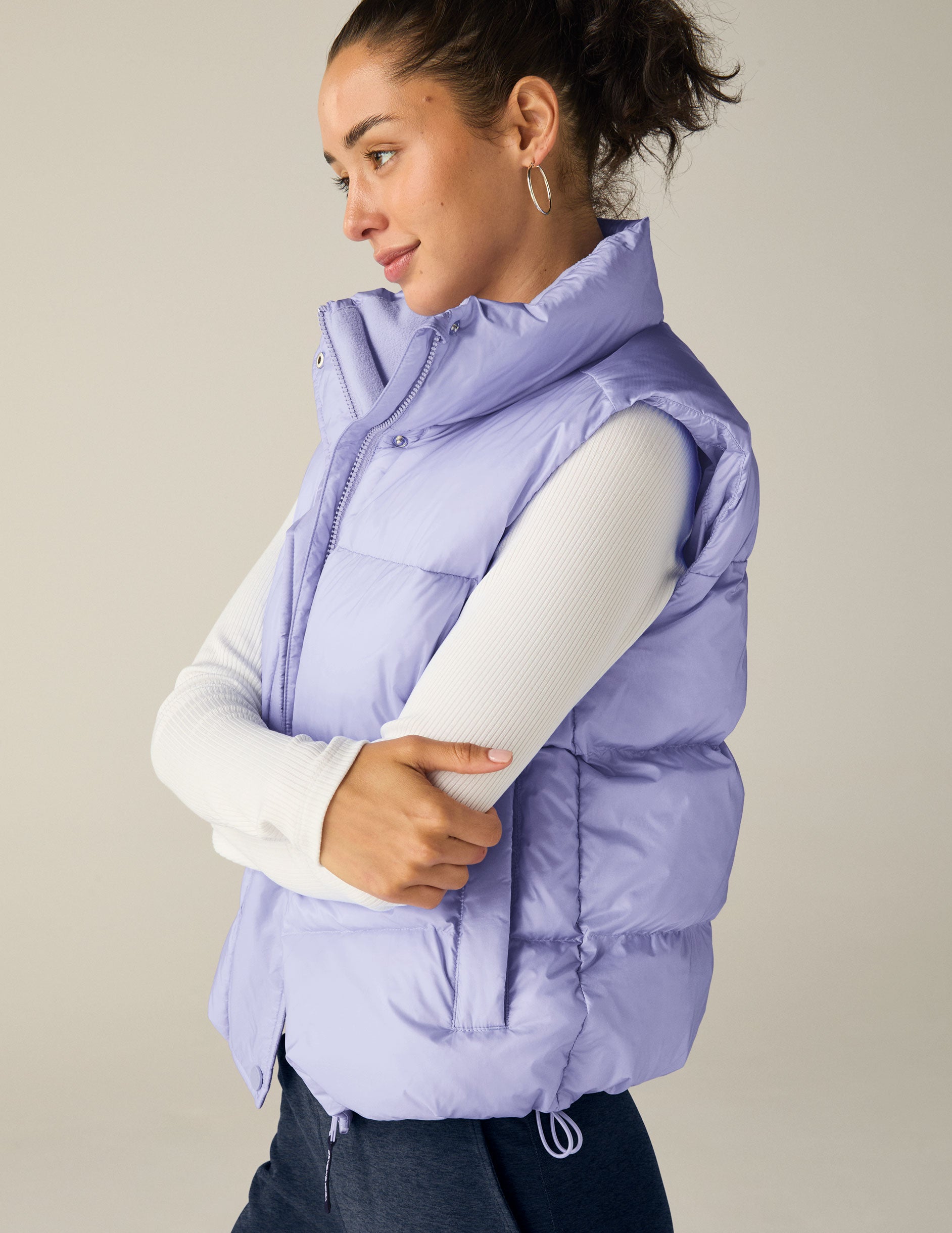 blue puffer vest with an interior bungee at hem. button and zip-up. interior and exterior pockets.