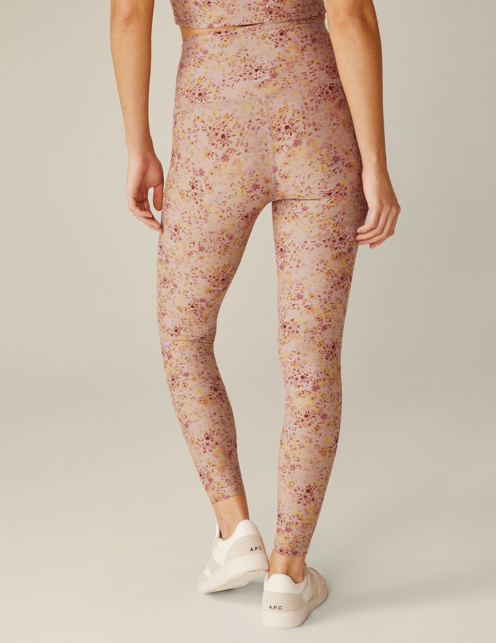 pink high-waisted midi leggings with a floral pattern. 