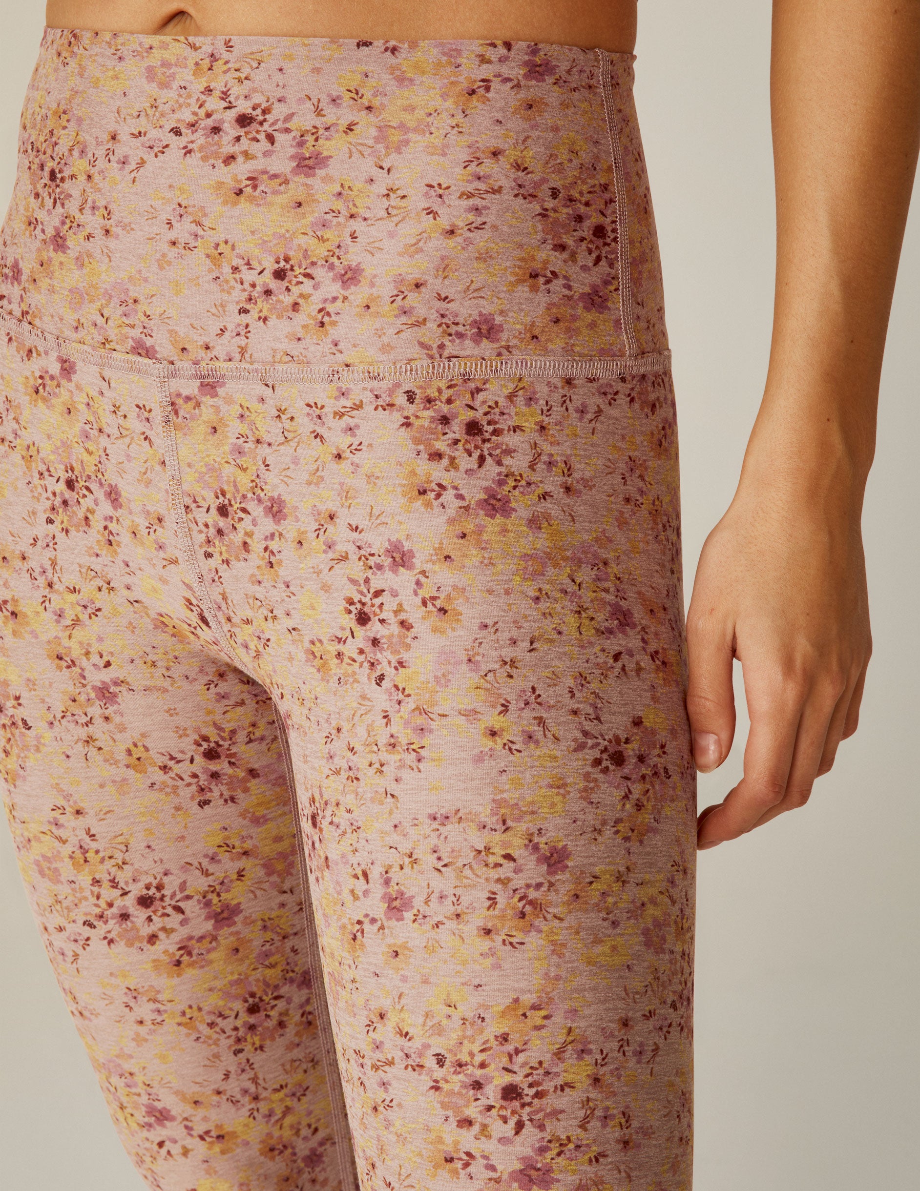 pink high-waisted midi leggings with a floral pattern. 