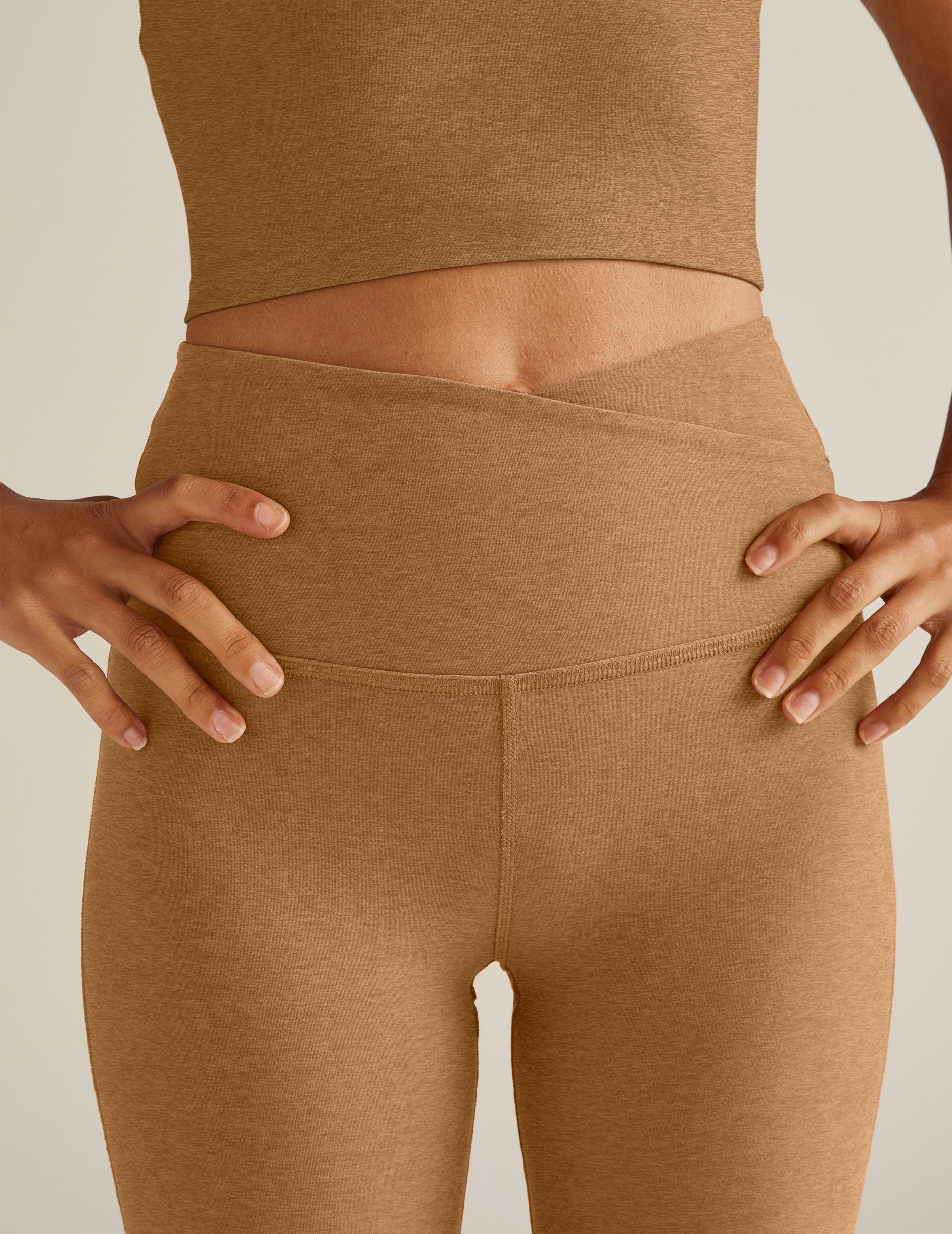 brown high-waisted flare leggings with a crossover detailing on the front waistband.