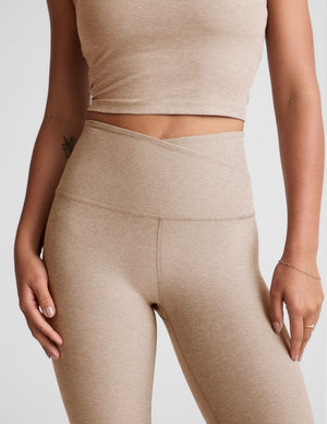 brown high-waisted midi length leggings with a crossover detail on the front waistband.