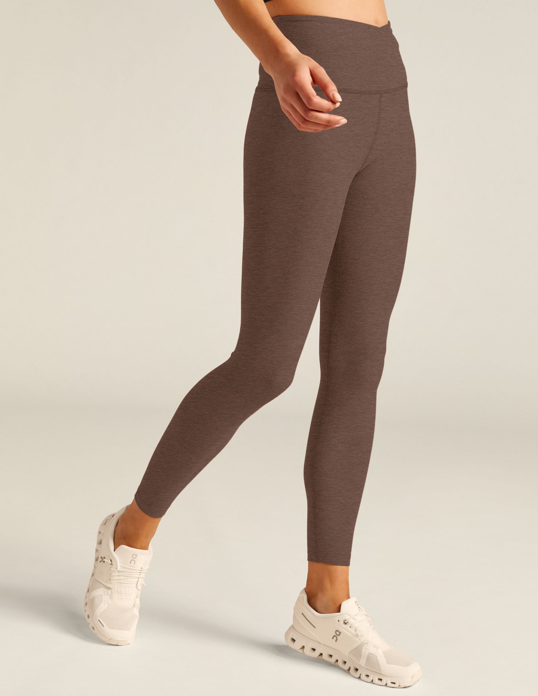 brown high-waisted midi leggings with a front crossover design on the waistband. 