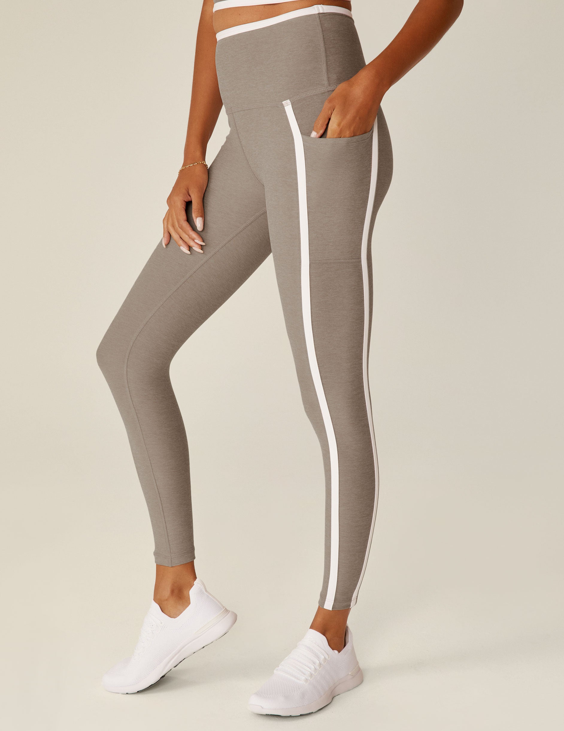 brown high-waisted pocket midi leggings with white line detailing around waistband and down the sides. 
