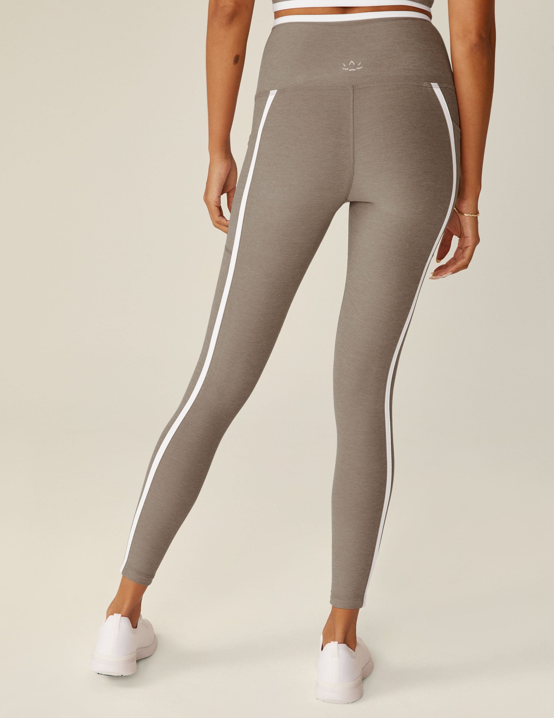 brown high-waisted pocket midi leggings with white line detailing around waistband and down the sides. 