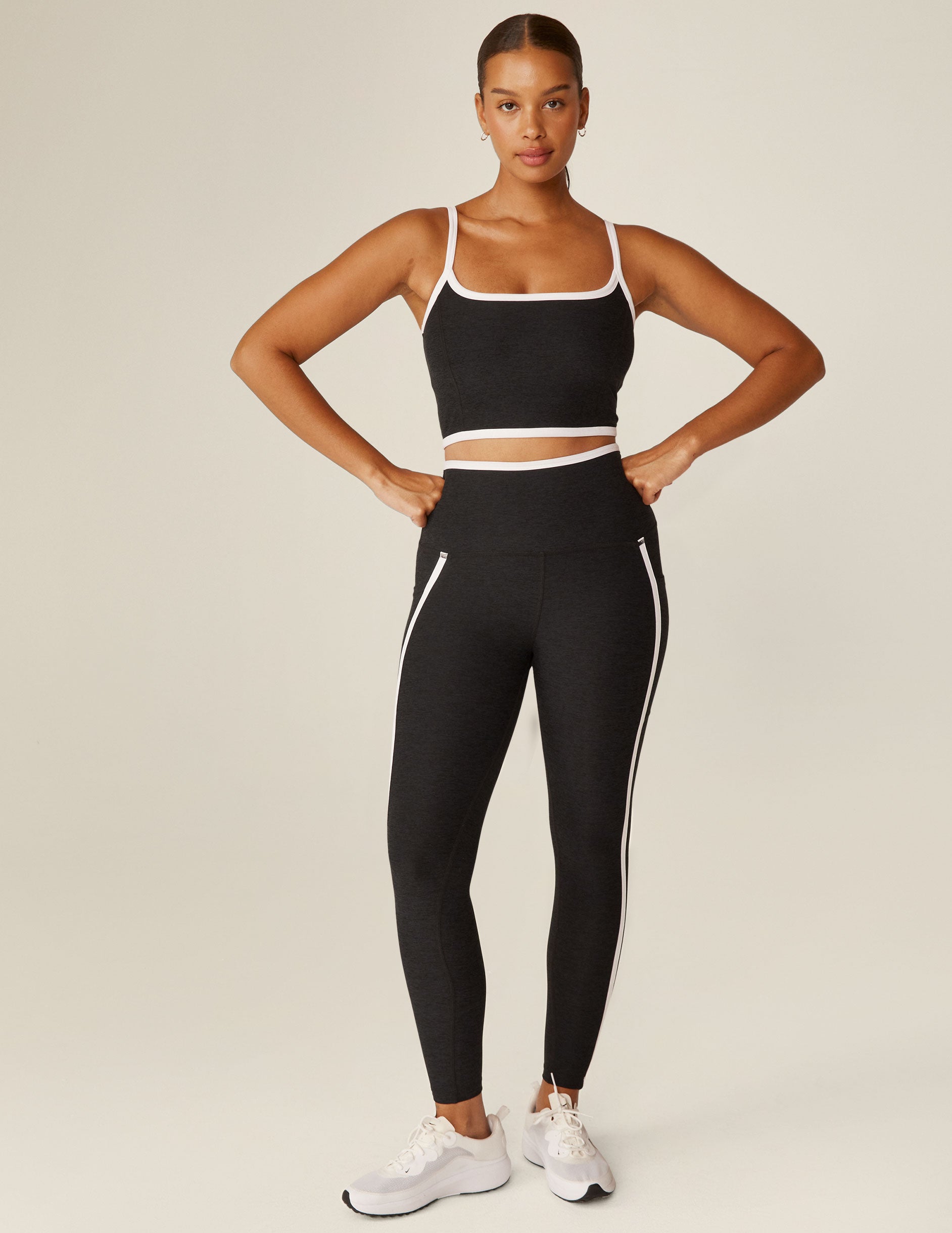 black pocket high-waisted midi legging with white lining around waistband and down the sides. 