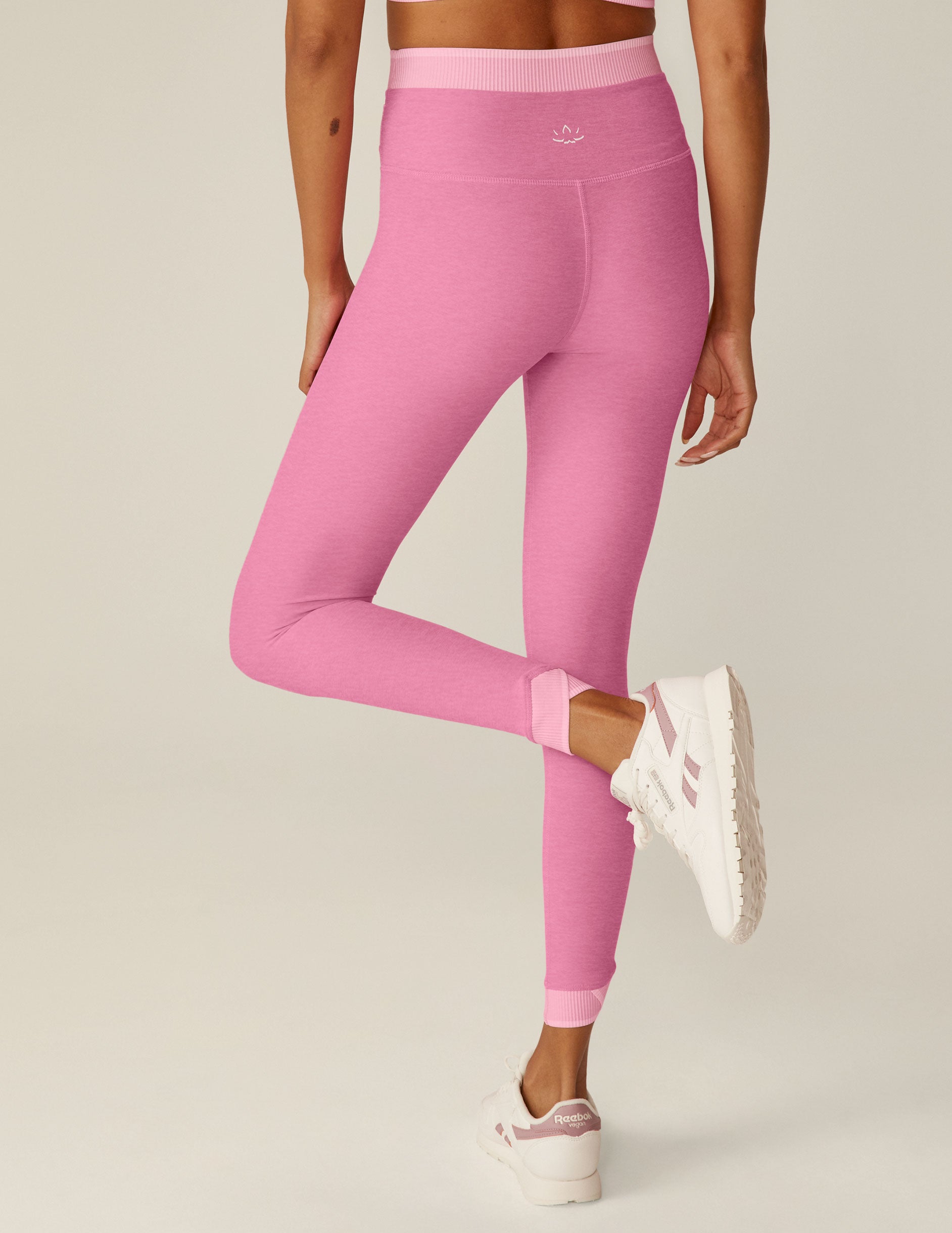 pink high-waisted midi leggings with a crossover and outline detailing on the waistband. 