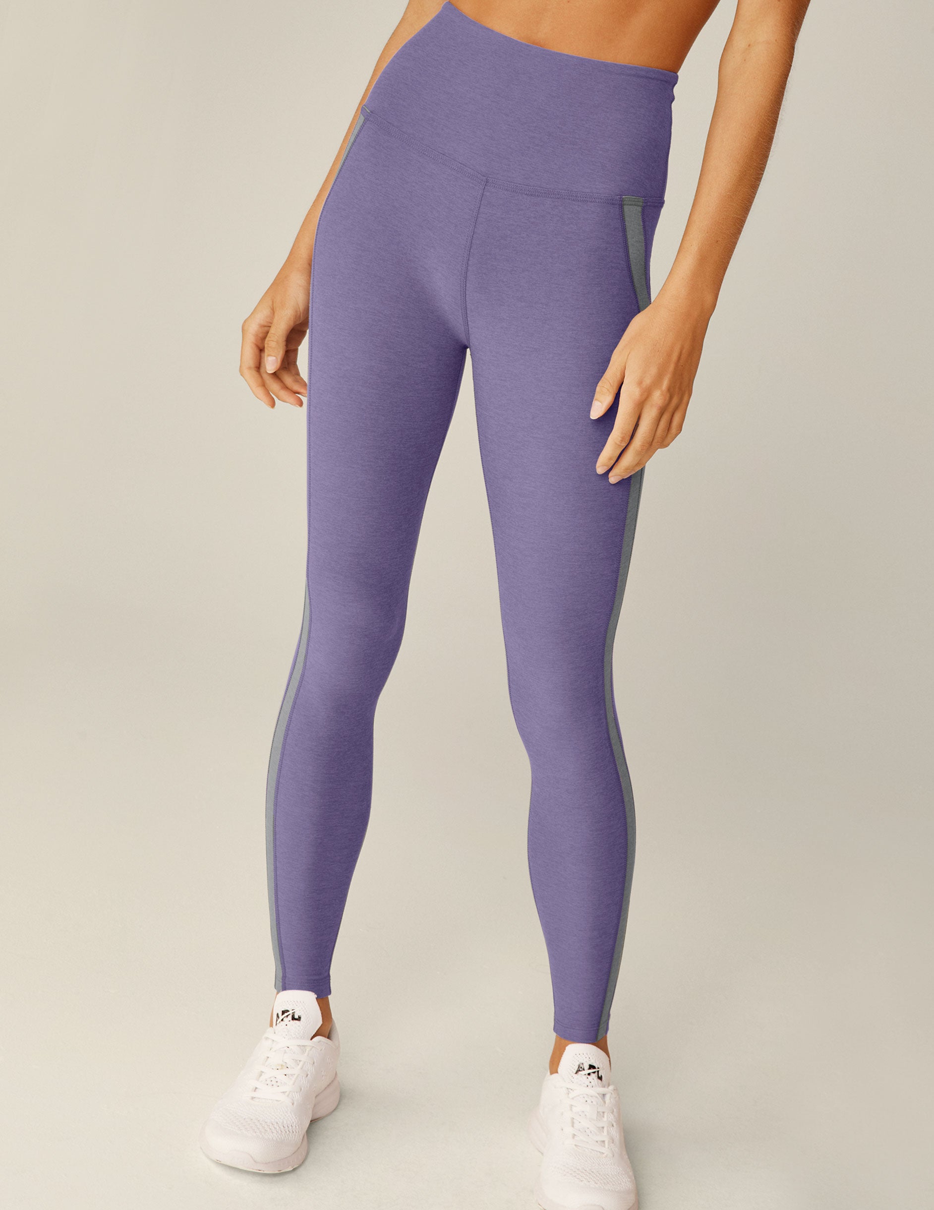 purple high-waisted midi leggings with gray trim down the side. 