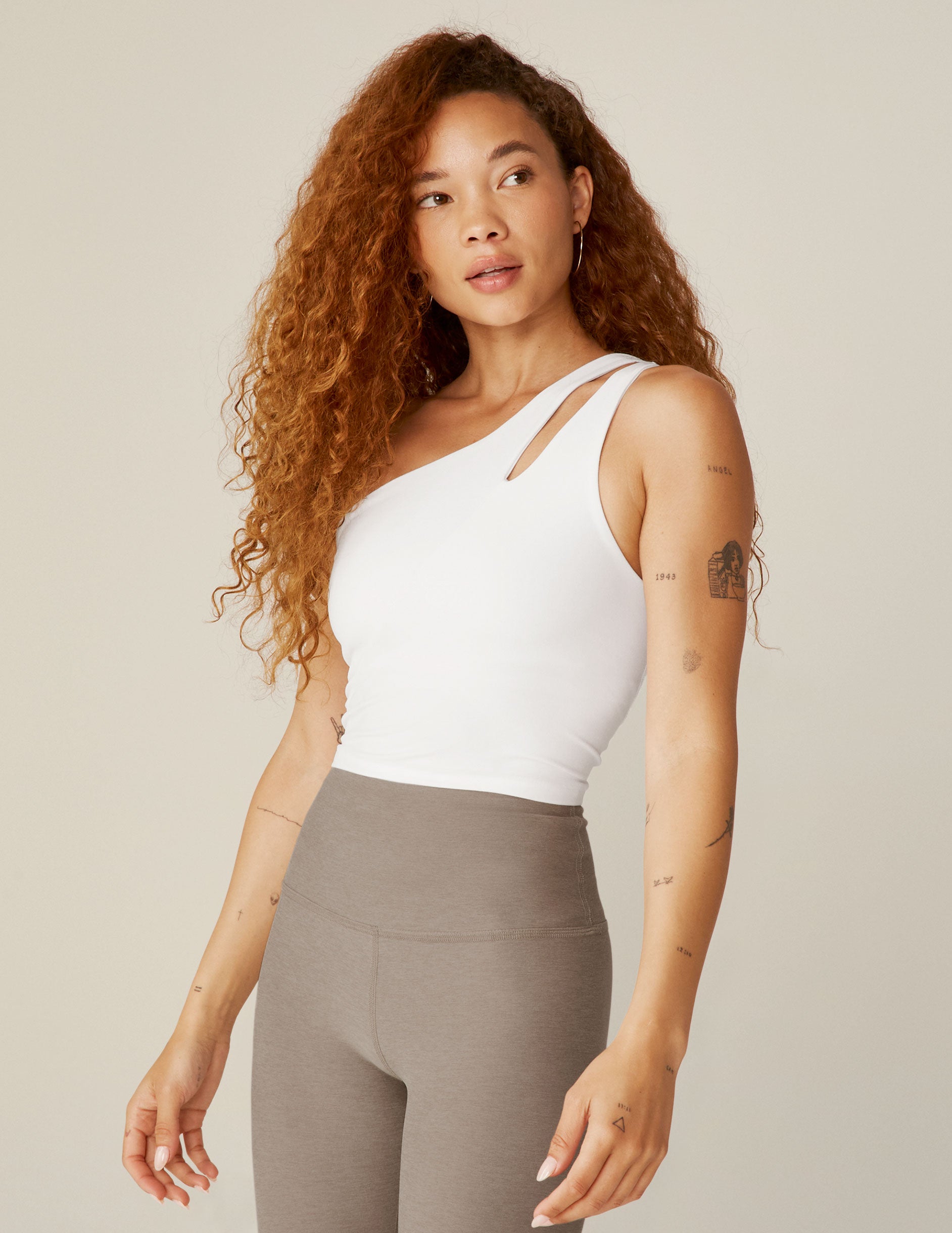 white one-shoulder cropped tank with a cut out detail on front strap and twist detail on back strap.