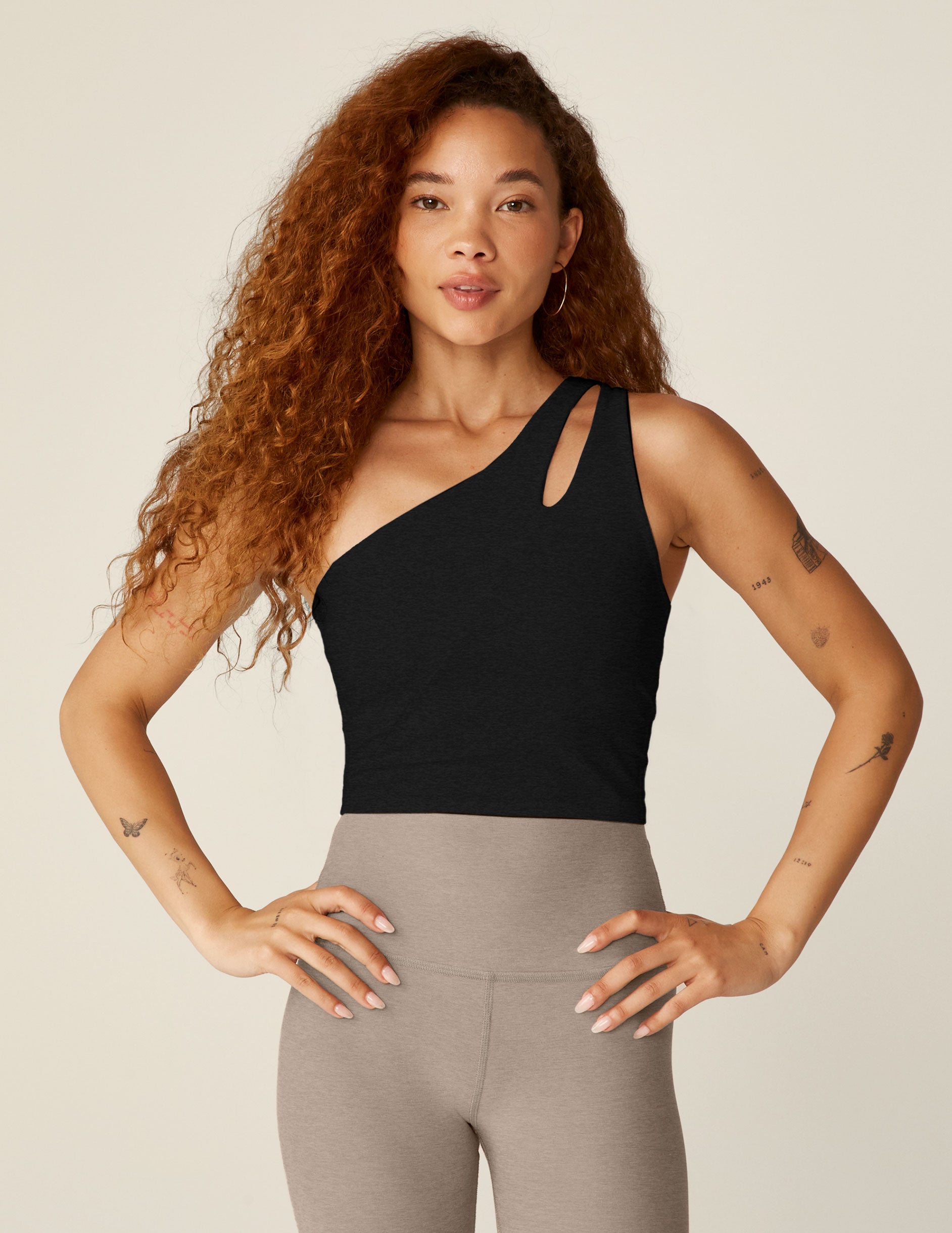 black one-shoulder cropped tank with a cutout on the front strap and a detailing on the back strap. 