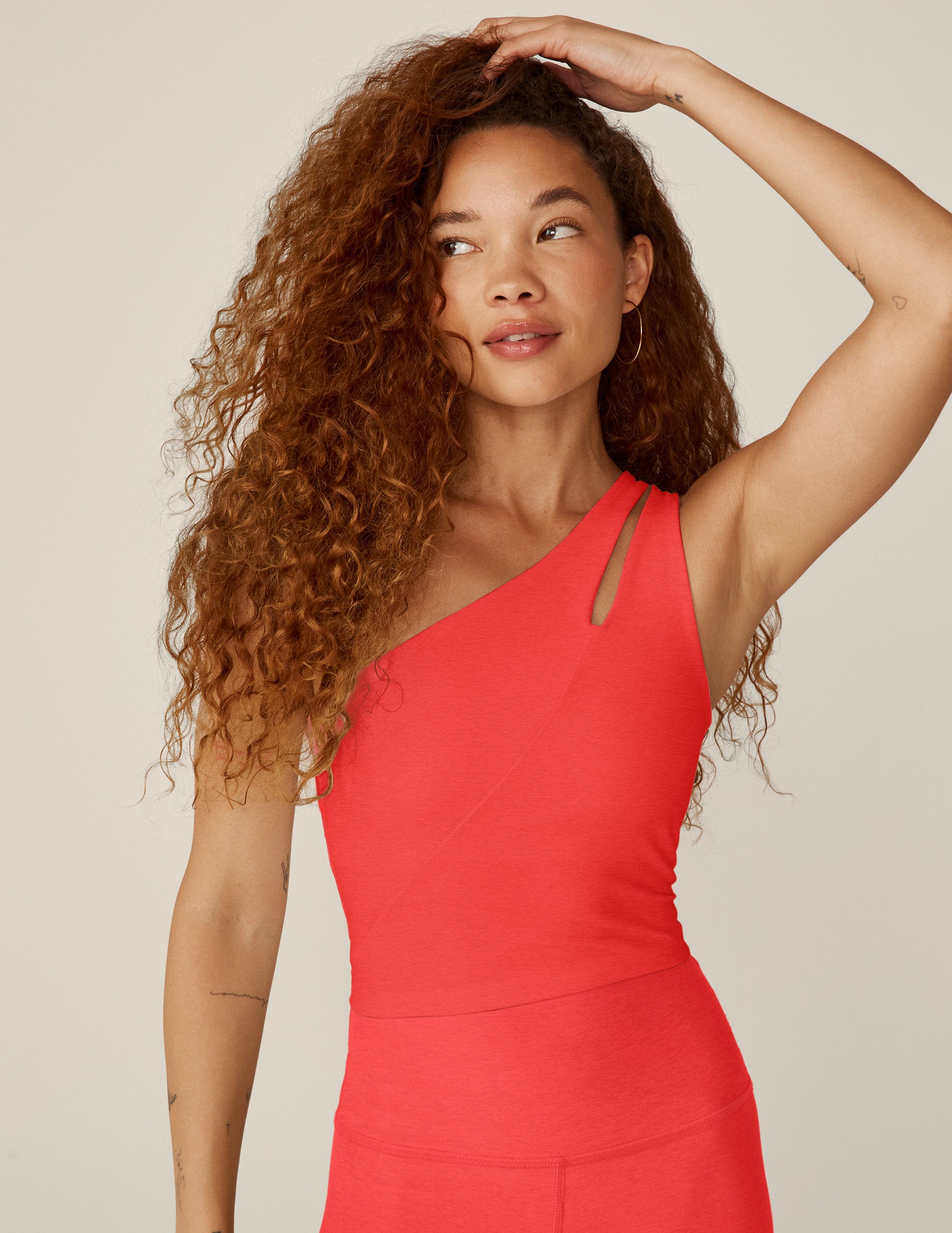 red one-shoulder cropped tank with an cut-out detail on the front strap and a twist detailing on the back strap. 