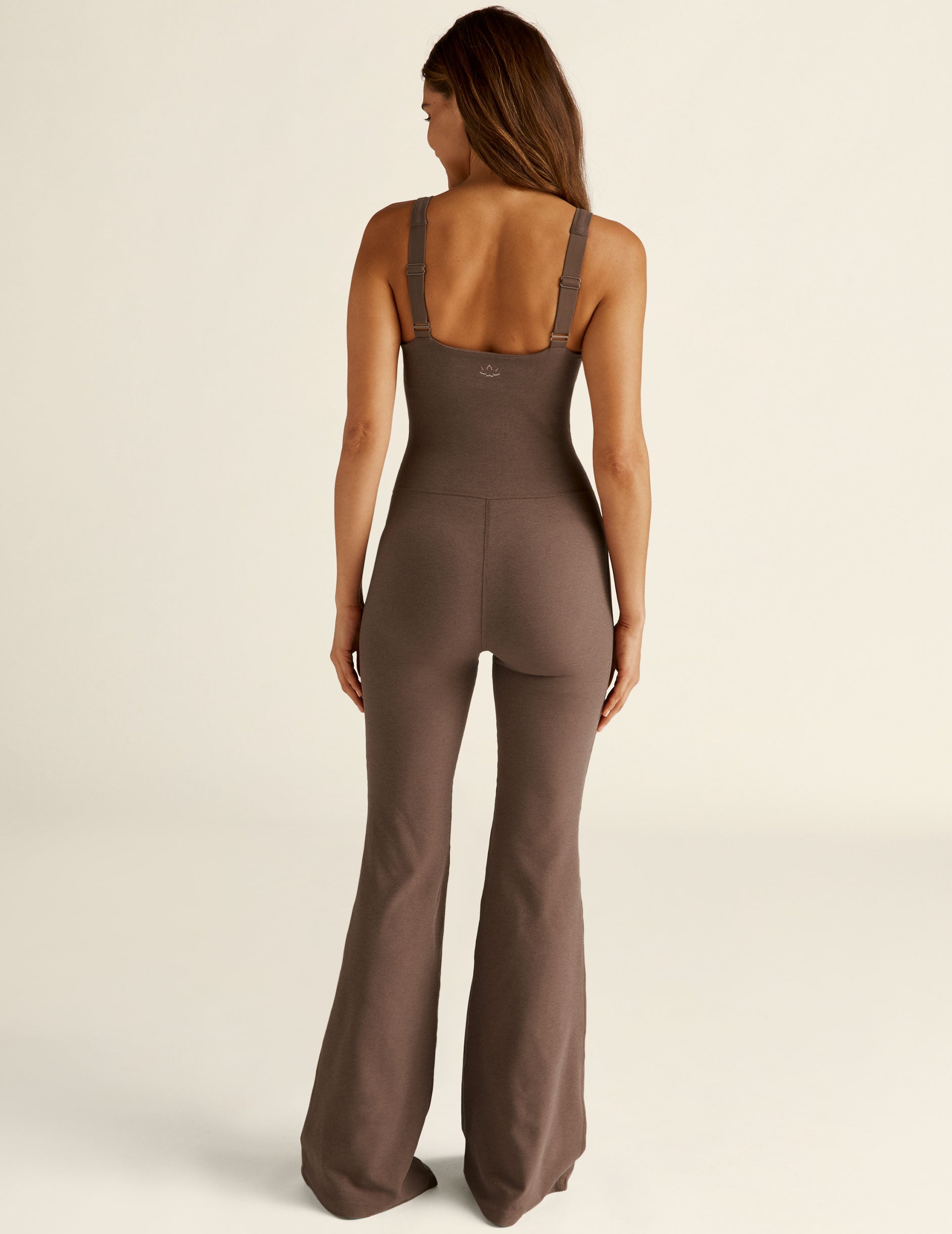 brown jumpsuit with flare bottoms and thin straps. 