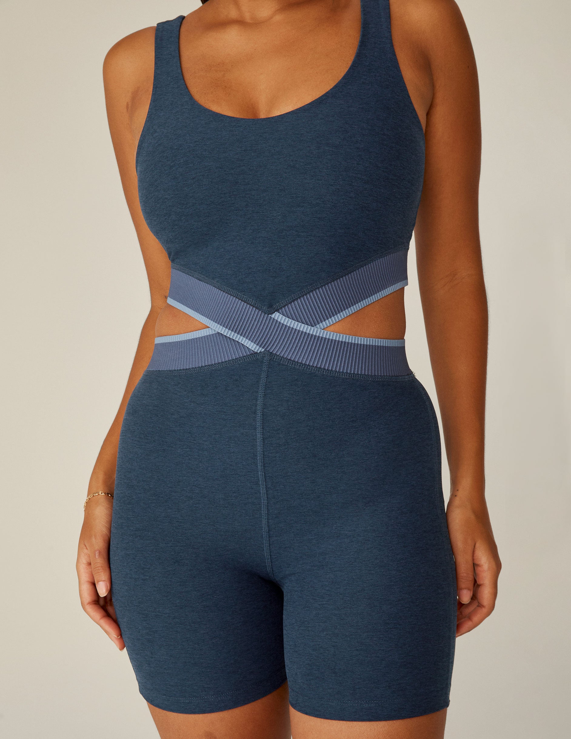 blue v-neck biker jumpsuits with an outline detail at waistband and cutouts on each side of the waistband. 