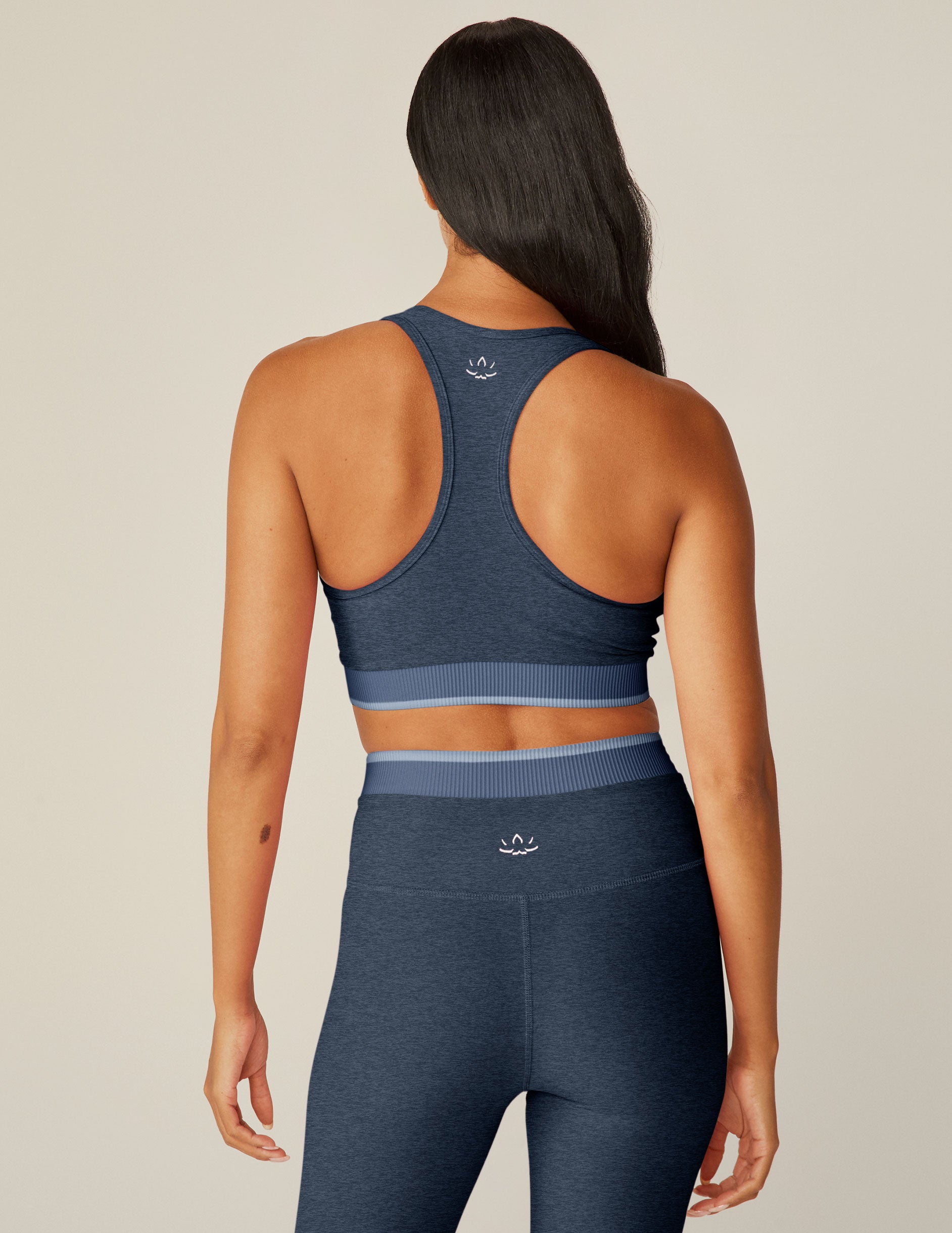 blue scooped neck racerback bra top with a front crossover and outlining detail.
