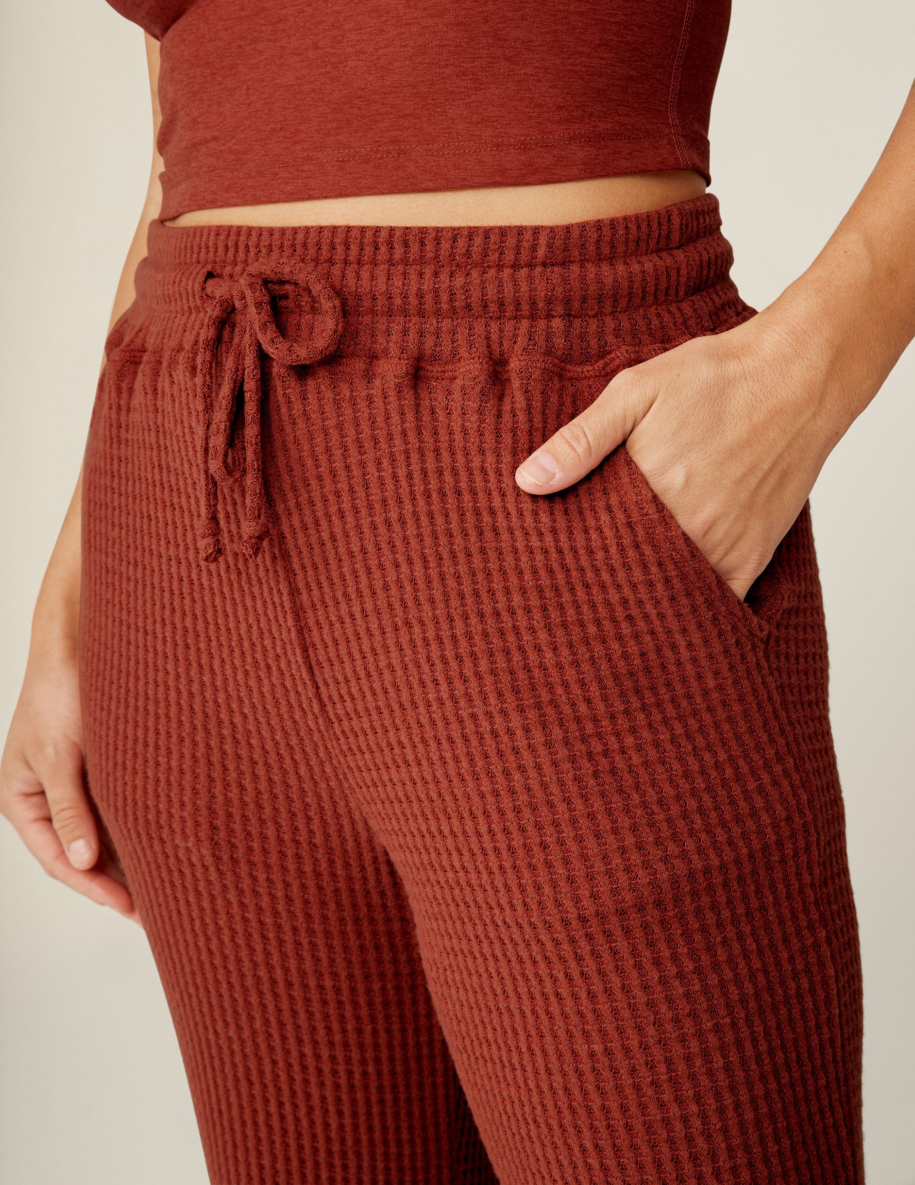 red waffle knit pants with a drawstring at waistband. 