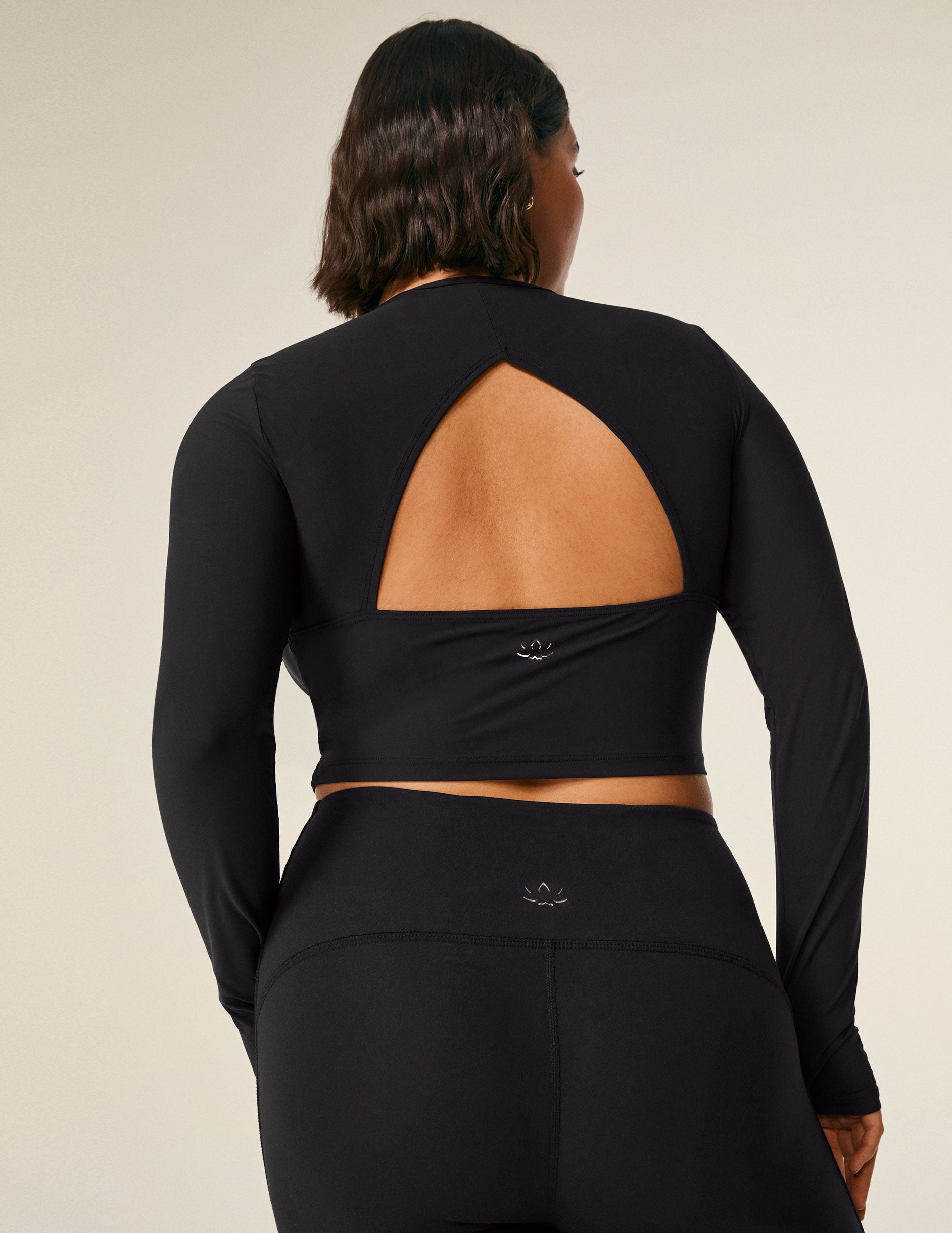 black long sleeve cropped top with an open back detail.