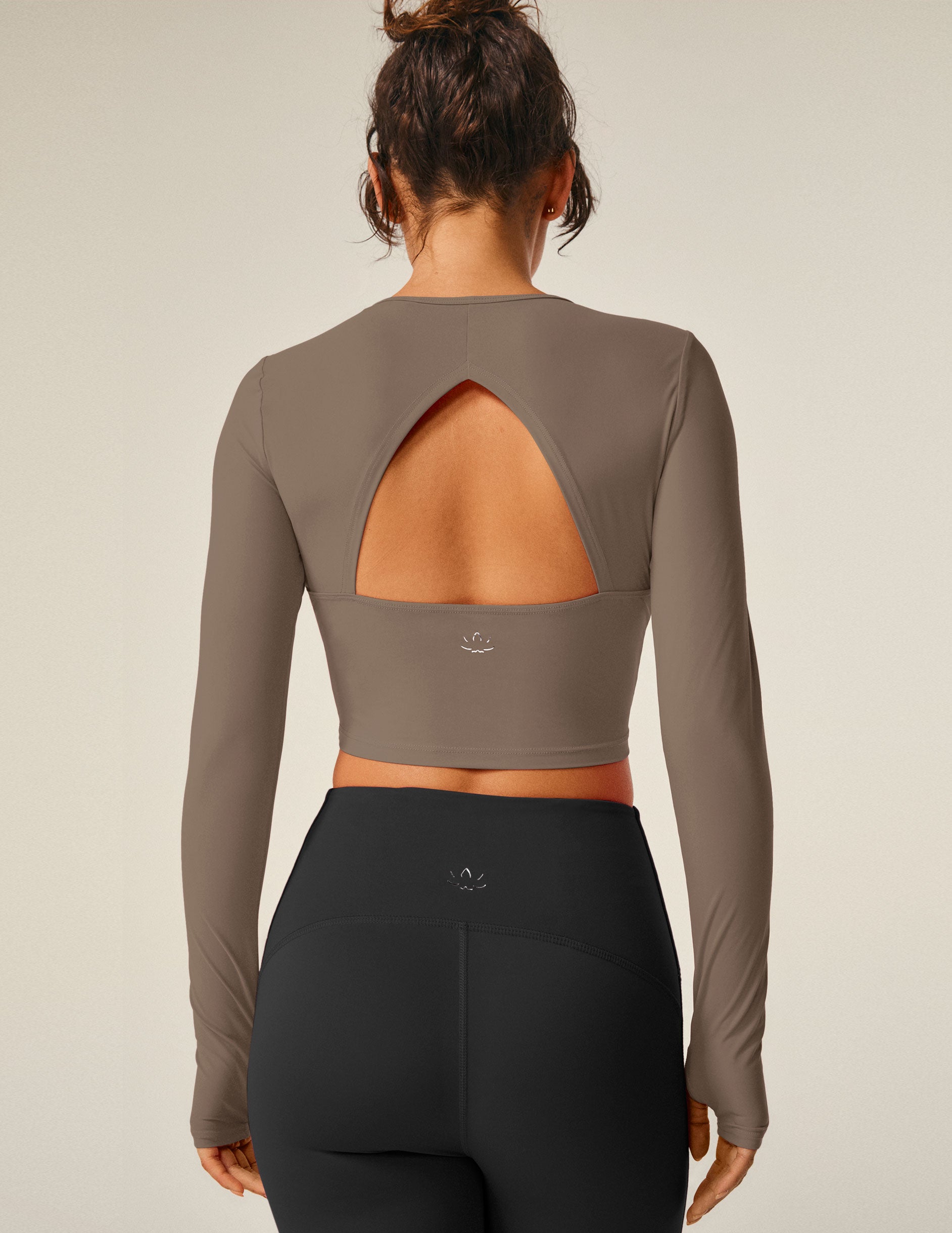 brown cropped long sleeve pullover with a back open detail and thumb holes.