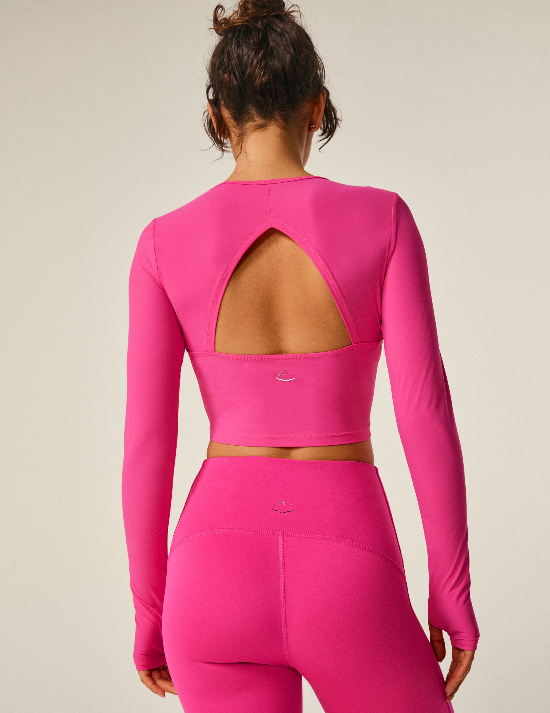 pink long sleeve cropped top with an open back detail.