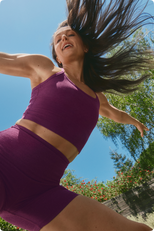 Megan Roup dancing wearing a purple Spacedye crop tank and matching pair of biker shorts