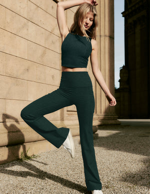 green tank top and green high-waisted bootcut pants. 