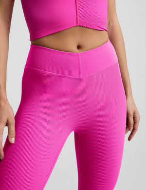 Woman wearing Pink Impulse Ribbed V-Waist Pedal Pusher Legging™ paired with a matching pink ribbed top.