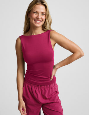 Woman wearing a red tank top and red pants against a plain background. 