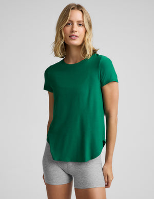 Woman wearing a green short sleeve t-shirt and gray 3