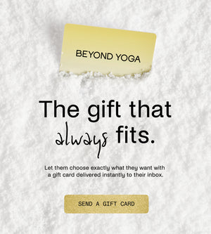 Promotional image for Beyond Yoga gift cards with text and a gold card on a textured white background.